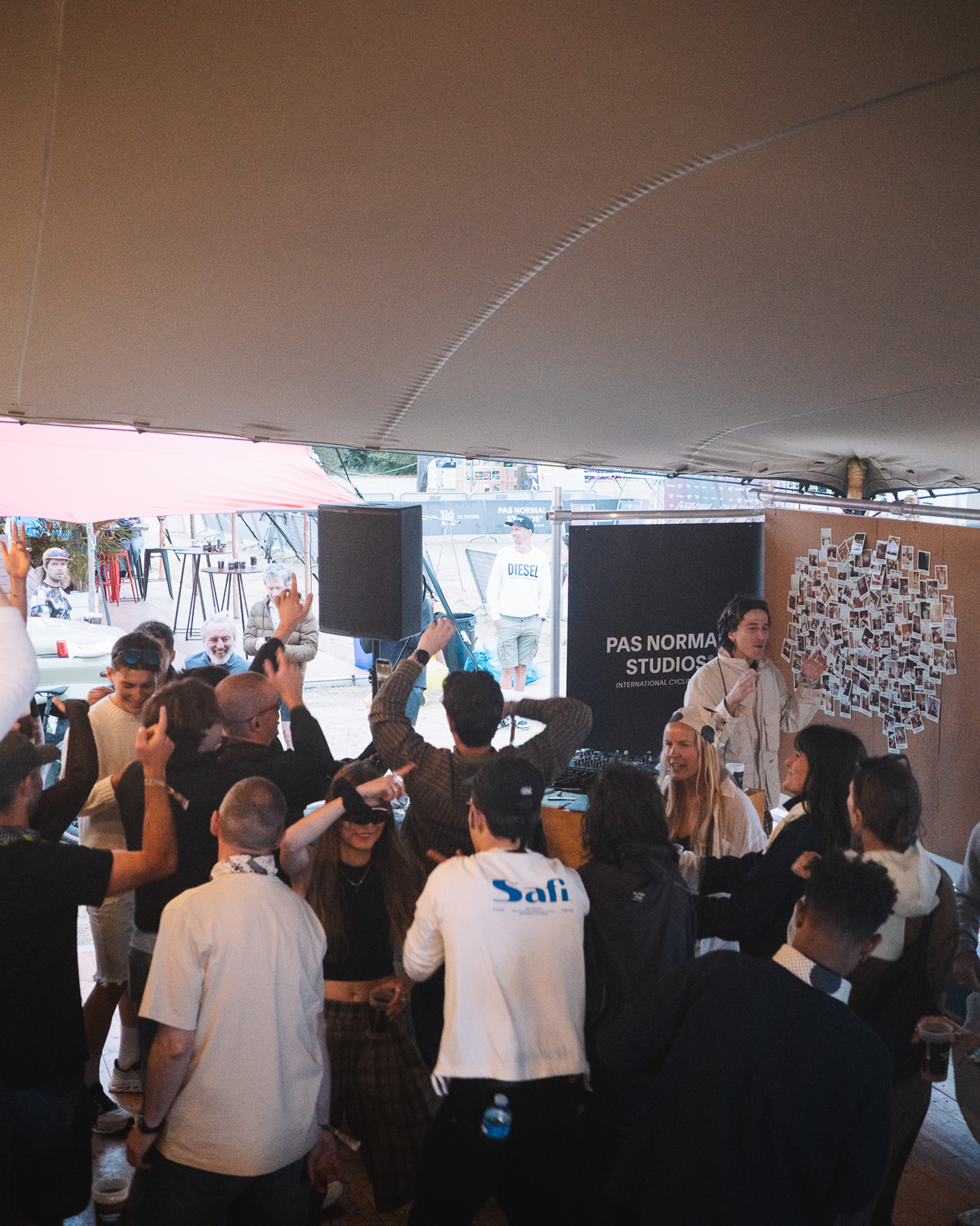 Crowd gathered at cycling event tent with brand display and photography setup