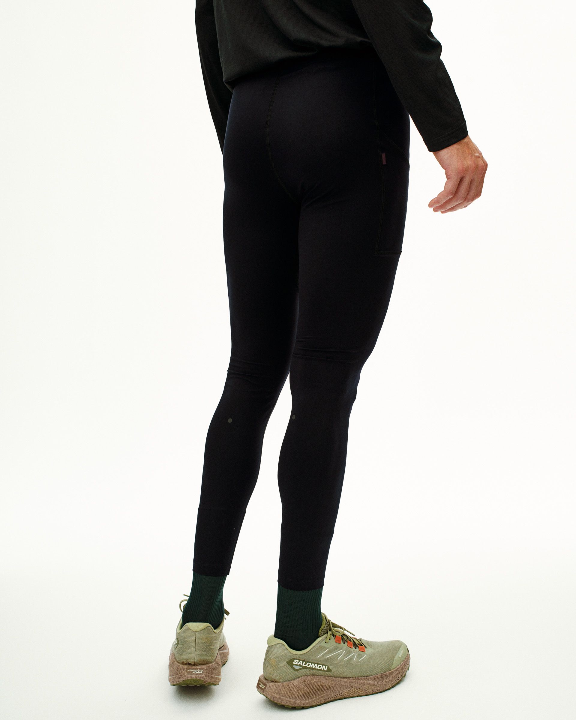 Black Balance long cycling tights on model, rear view with small logo detail at hip