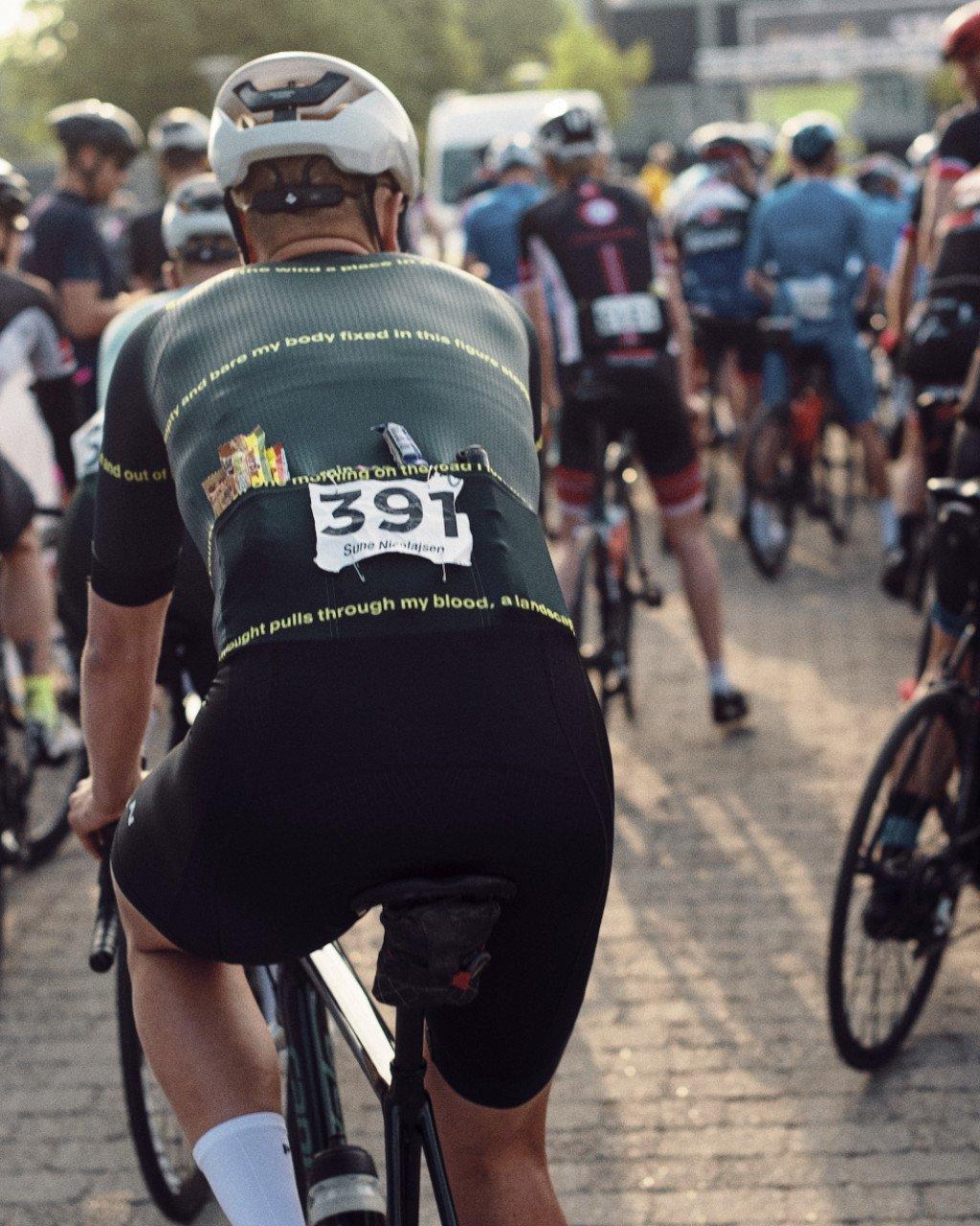 Cyclist wearing green jersey with yellow text and race number 391 at cycling event