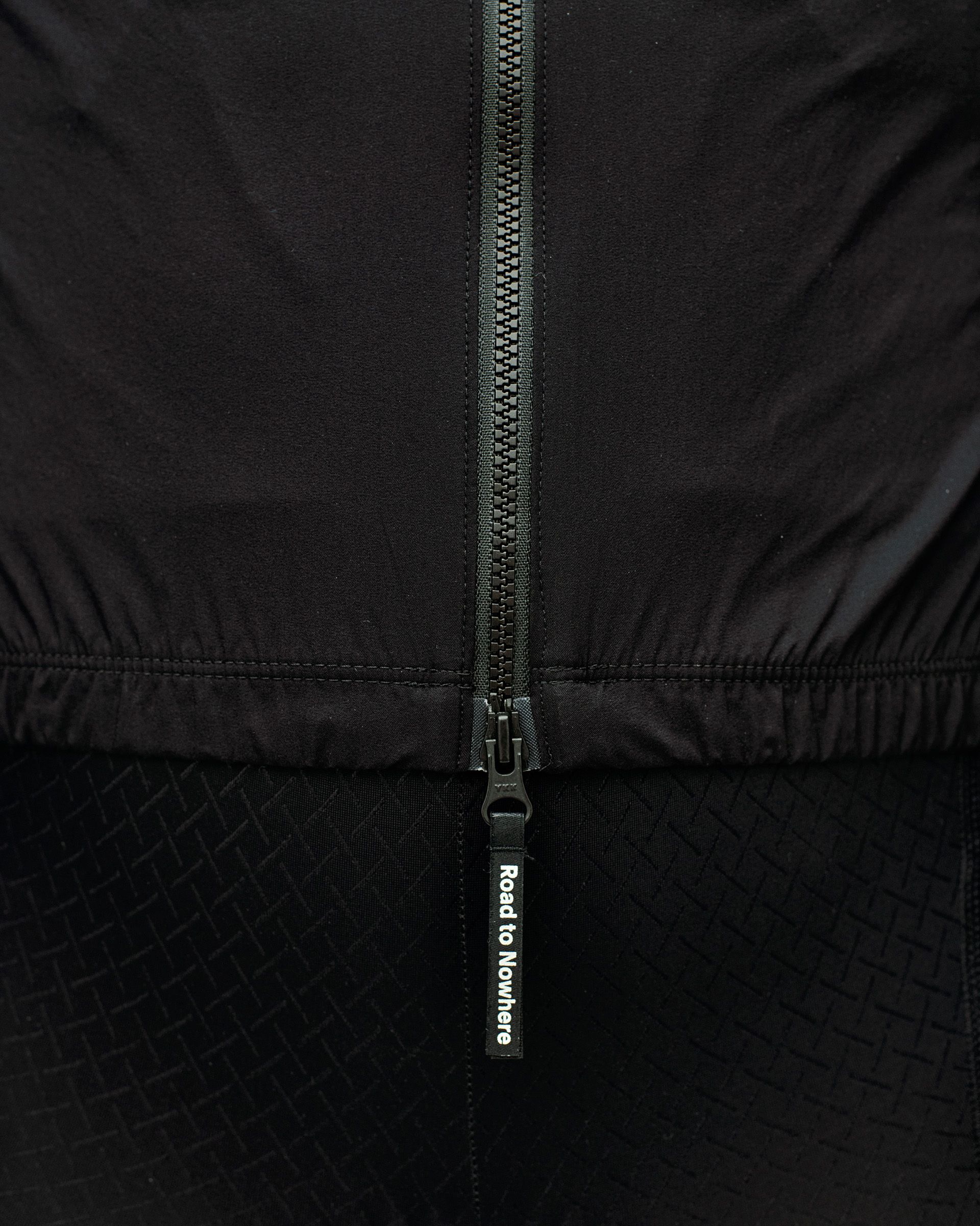 Black Mechanism Stow Away cycling jacket, detail view of centre zip with Road to Nowhere zip pull