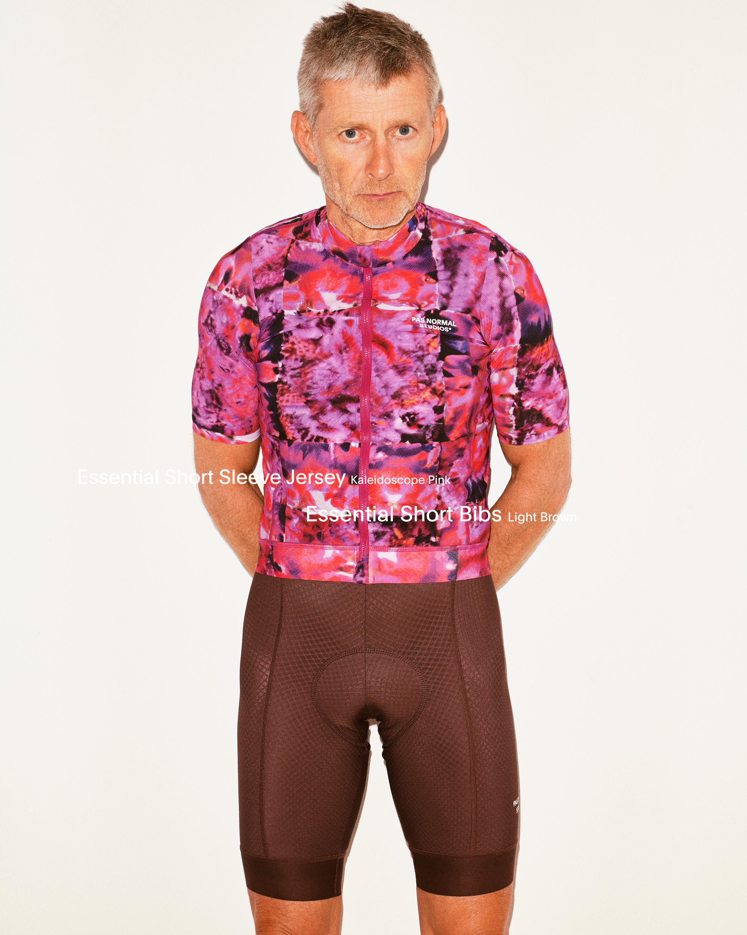 Model wearing Essential Short Sleeve Jersey in pink kaleidoscope pattern with Essential Short Bibs in brown