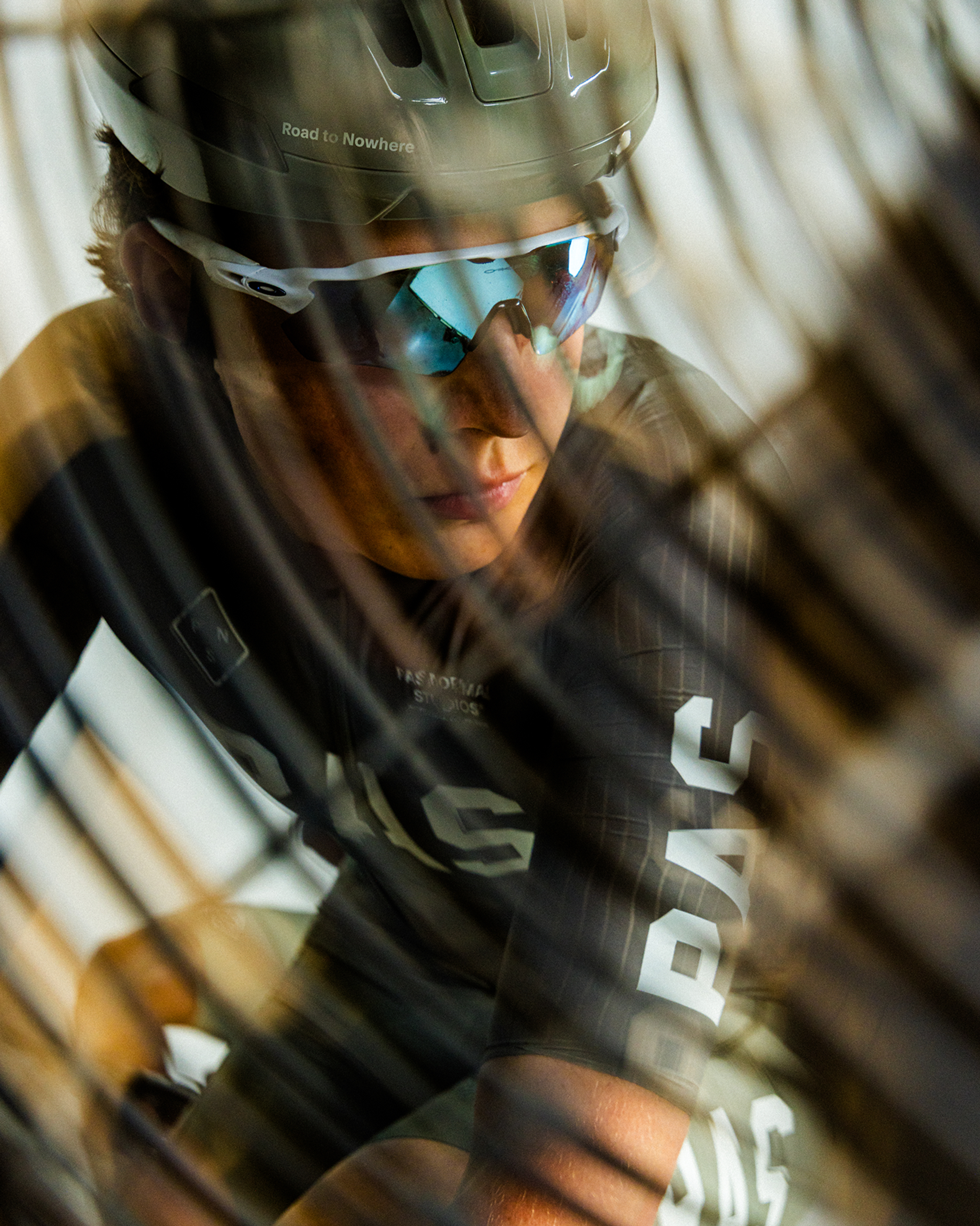 Model wearing black cycling gear with helmet and sunglasses in motion blur effect