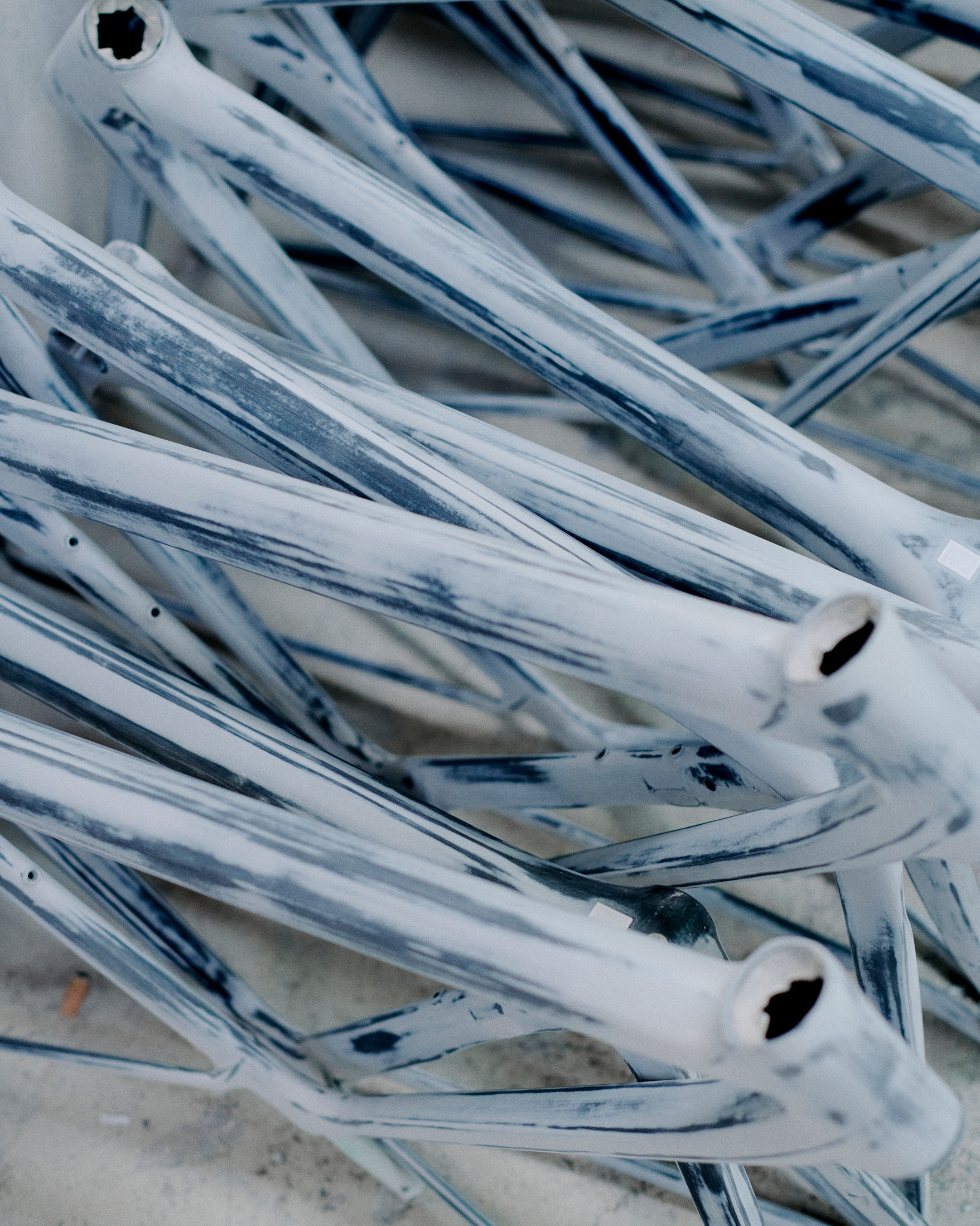 White and blue marbled bicycle frame tubes stacked together
