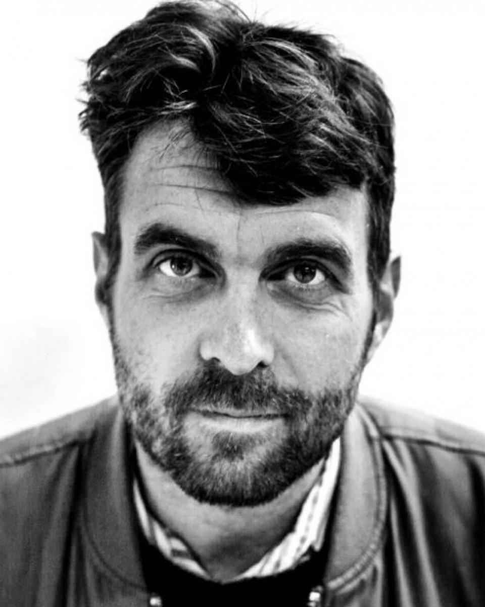 Black and white portrait of Karl-Oskar Olsen, bearded man with tousled hair looking directly at camera
