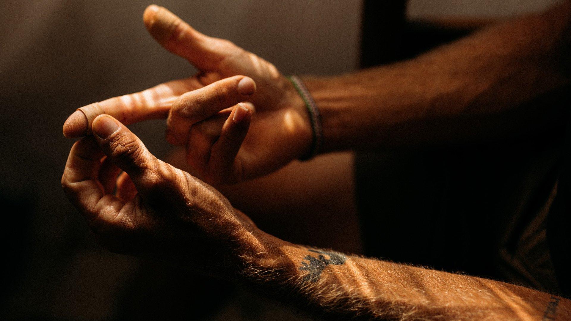 Close-up of cyclist's hands with tattoos in warm lighting