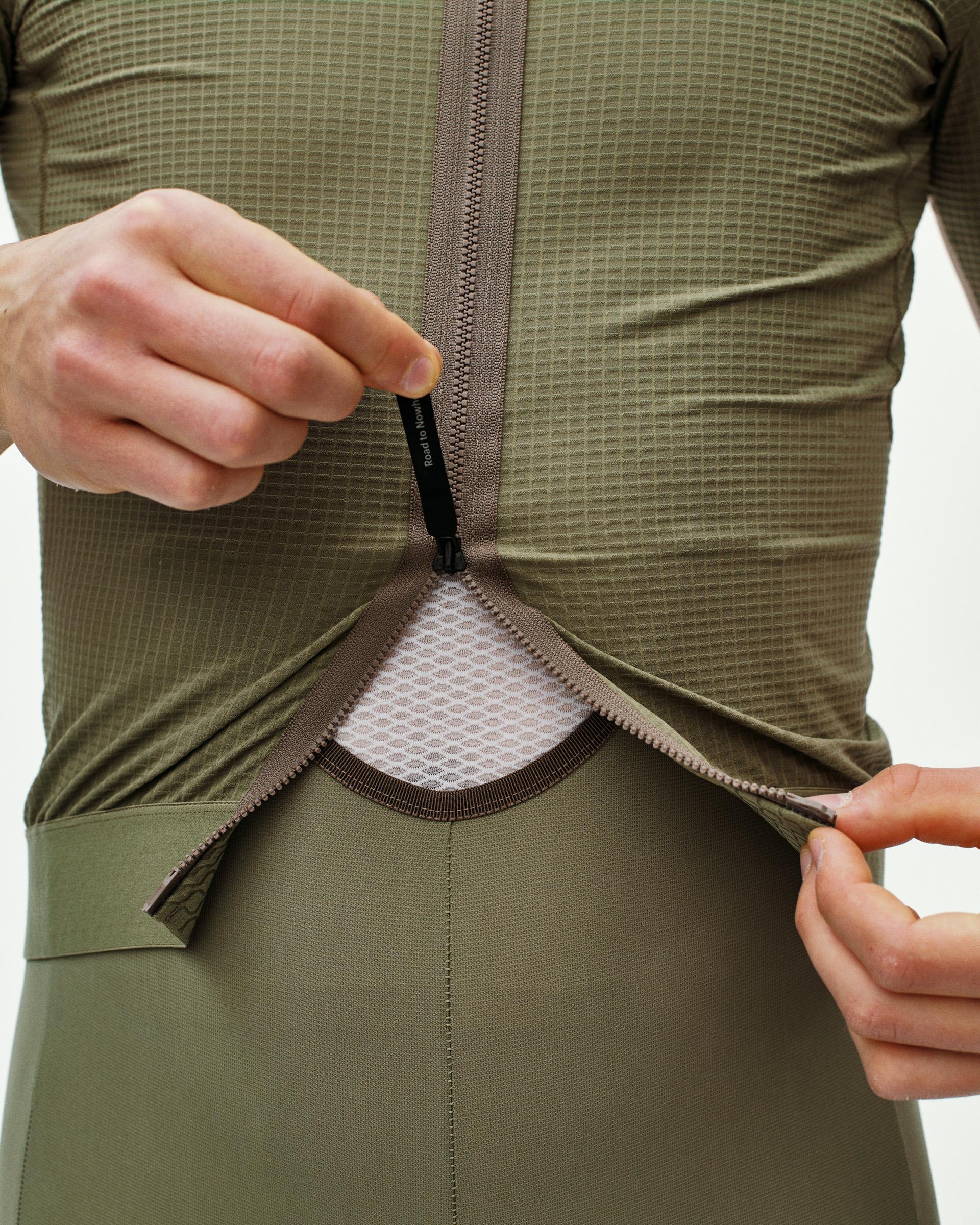 Light Olive Escapism cycling jersey on model with rear zip pocket being opened