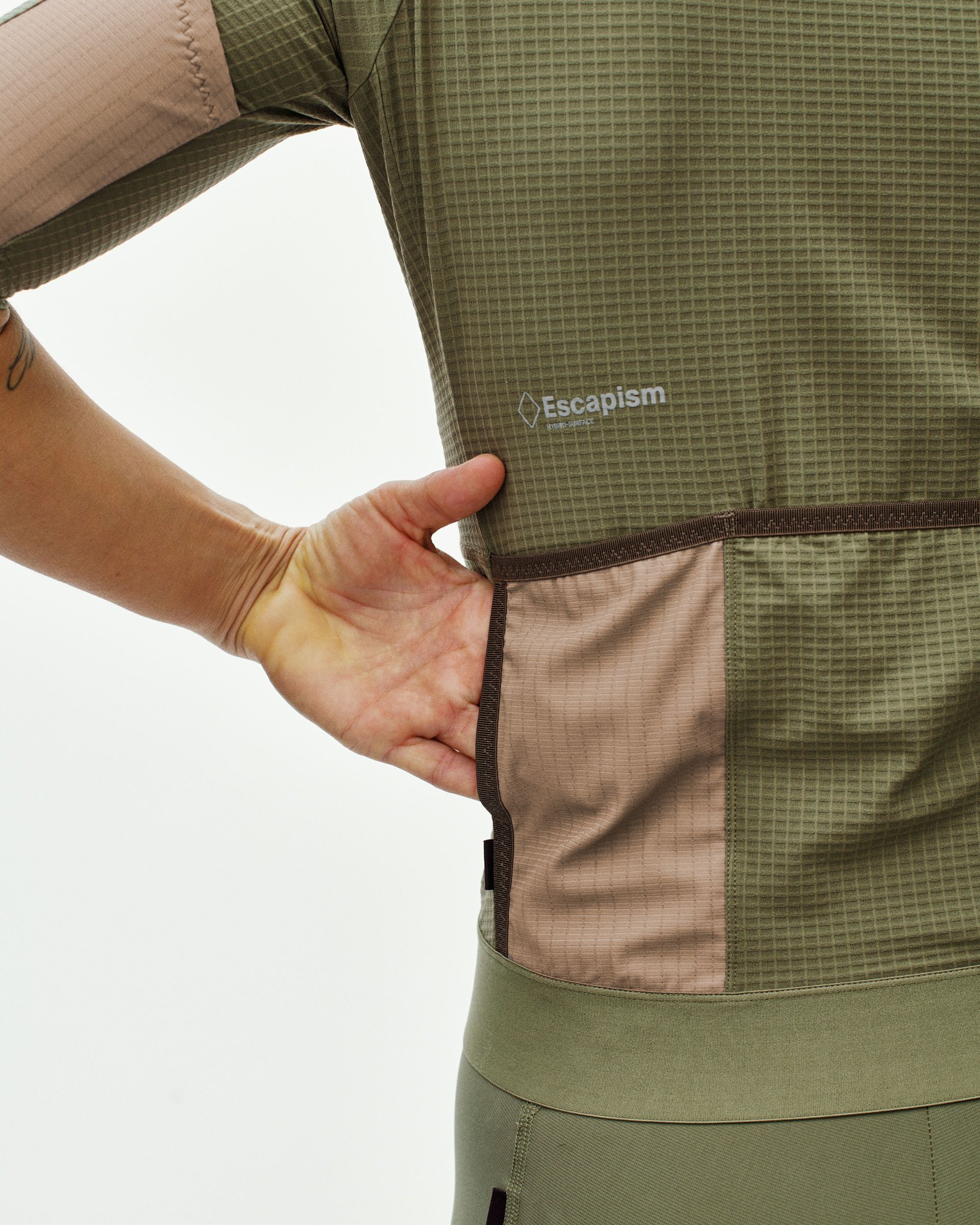 Light Olive Escapism cycling jersey on model, side view showing contrast chest pocket and grid texture