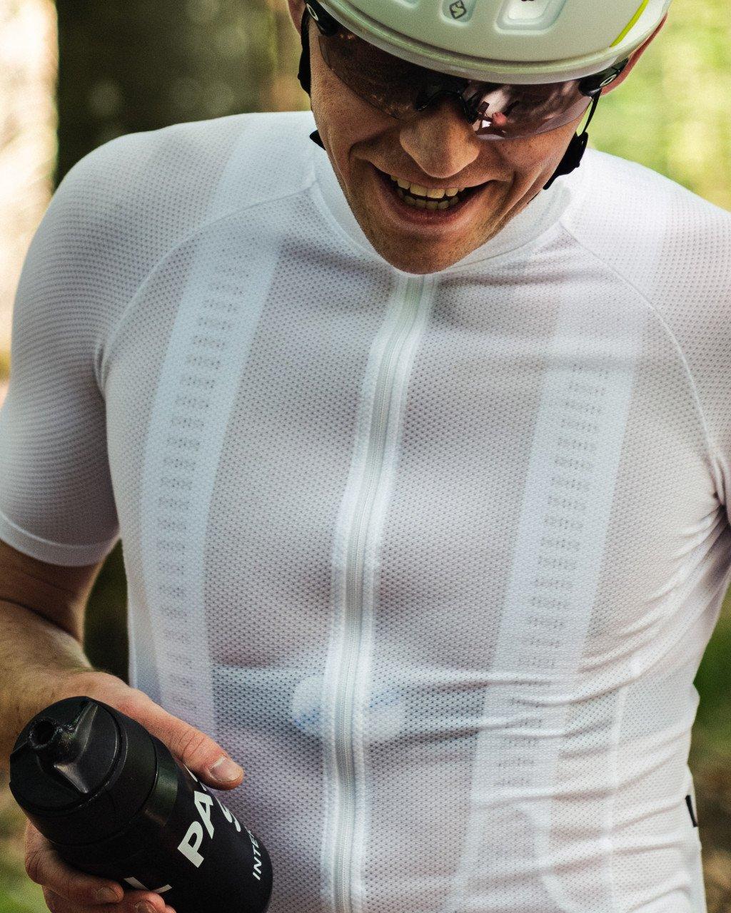 Model wearing white perforated cycling base layer with full-zip front and fitted sleeves