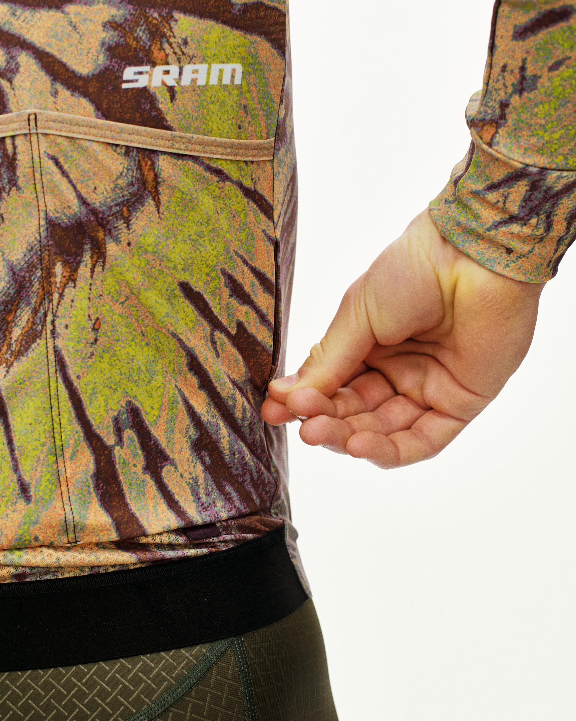 Beige STFR Mechanism long sleeve cycling jersey on model with abstract print and white SRAM branding