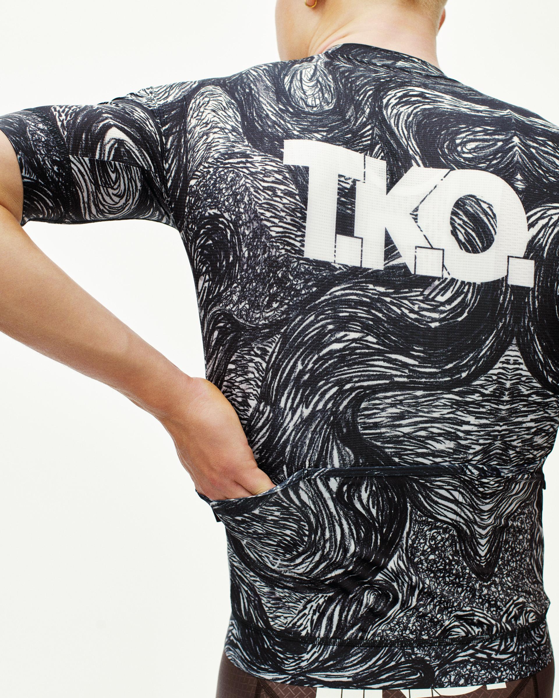 Iron Grey T.K.O. Mechanism cycling jersey on model, rear view with all-over swirl print and white back logo