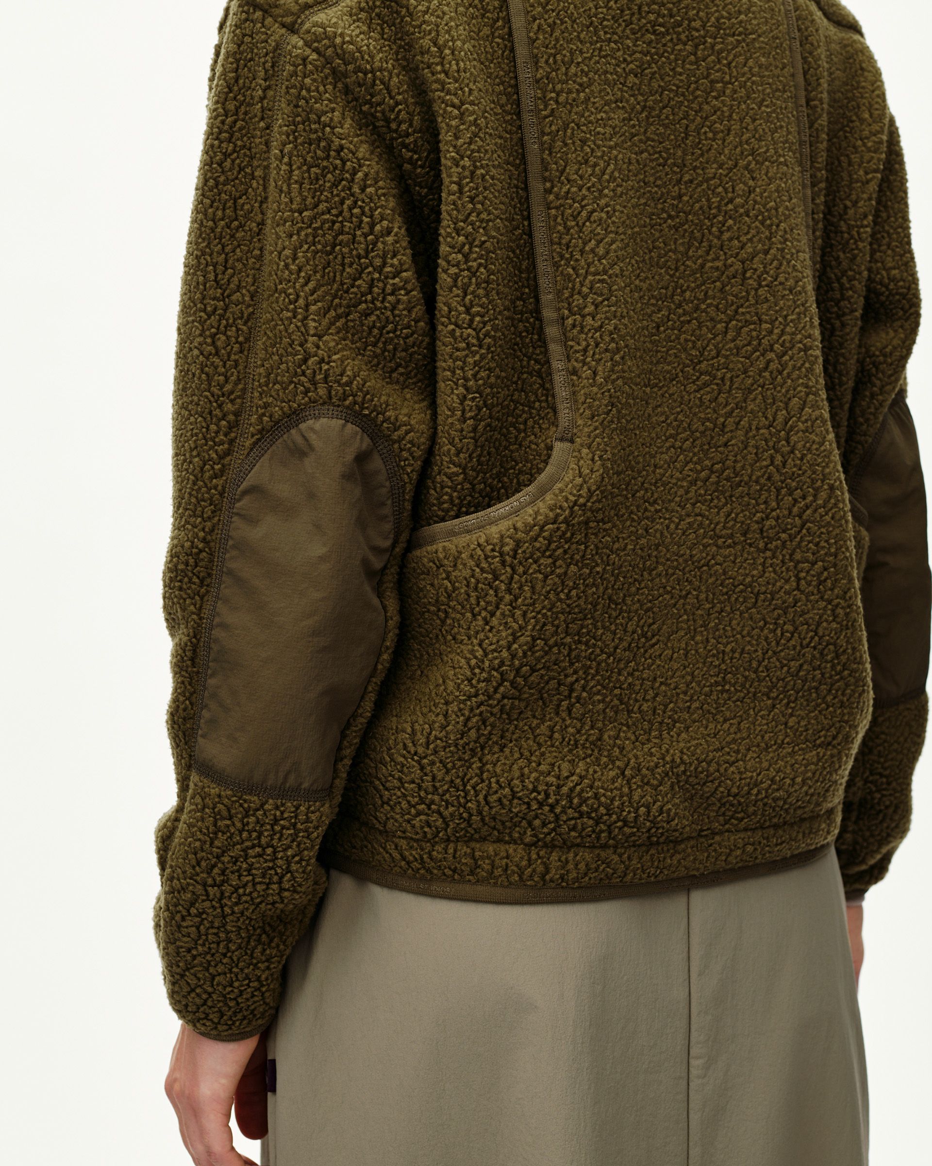 Deep Olive Off-Race Pile Fleece jacket on model, side detail view with contrast elbow patch and zip pocket