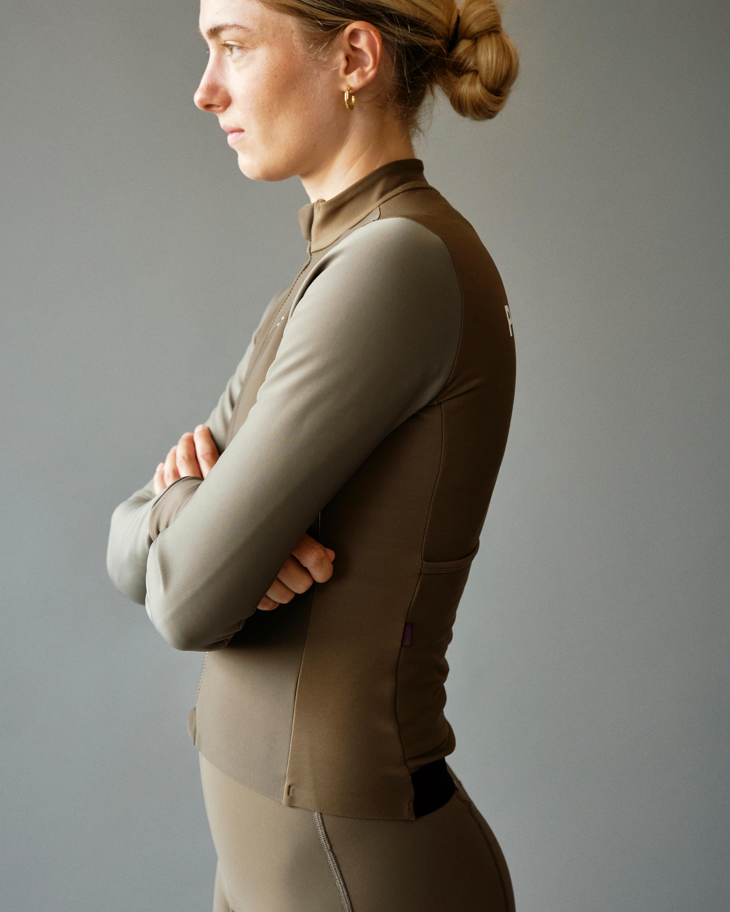 Brown Mechanism Thermal long sleeve cycling jersey on model, side view with quarter zip