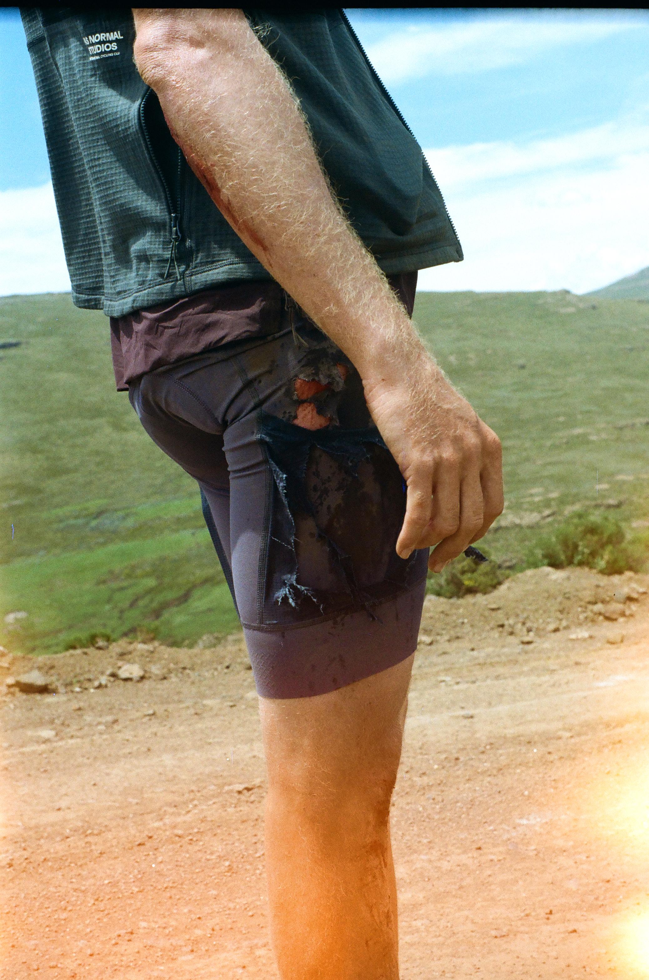 Model wearing black cycling shorts with decorative pattern in outdoor landscape setting