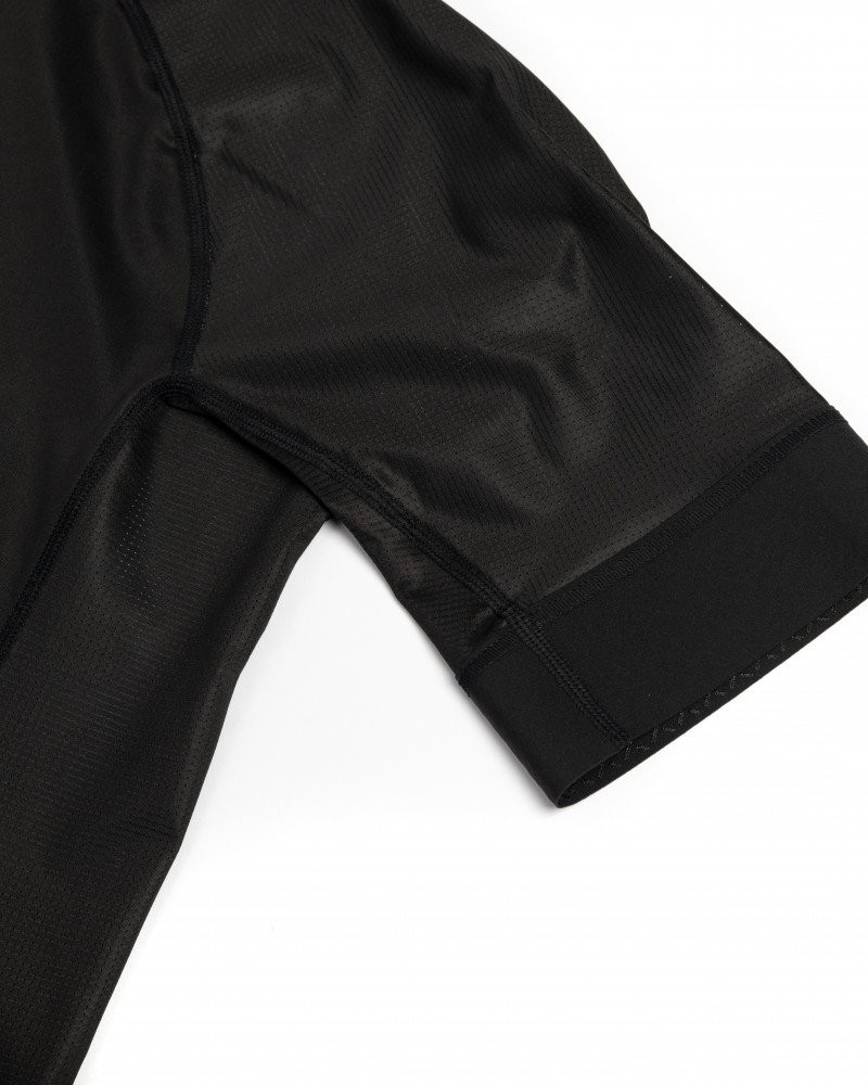 Black Mechanism cycling jersey, detail view of sleeve hem with ribbed cuff