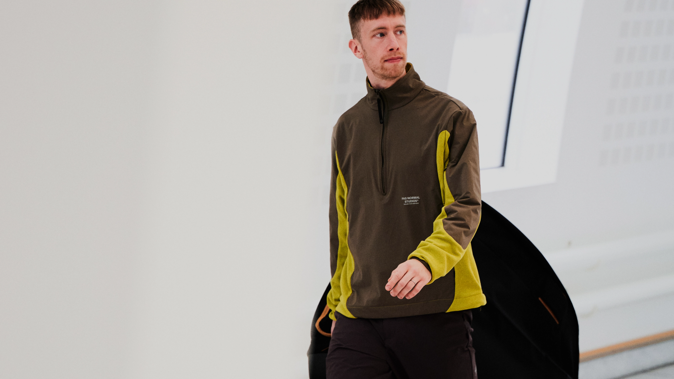 Black Off-Race Tech pants on model with yellow side panels and half-zip pullover