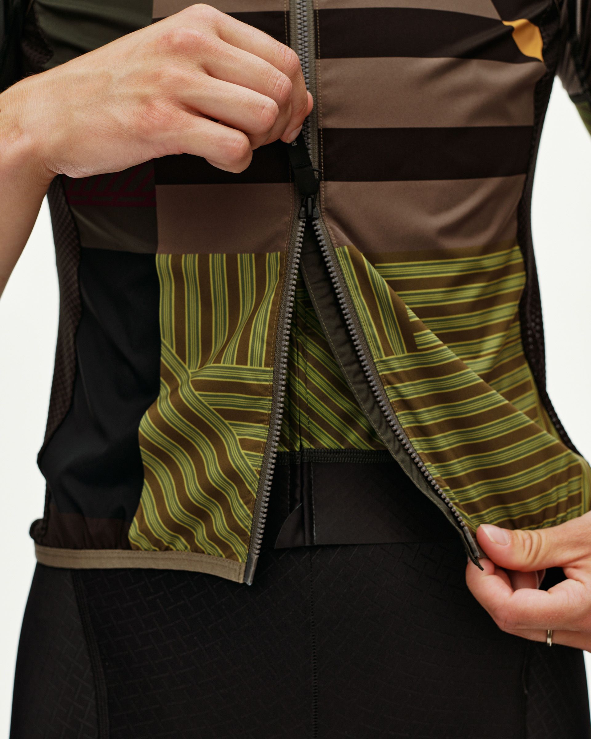 International Earth brown Mechanism Stow Away cycling gilet, front detail on model showing open zip with printed liner