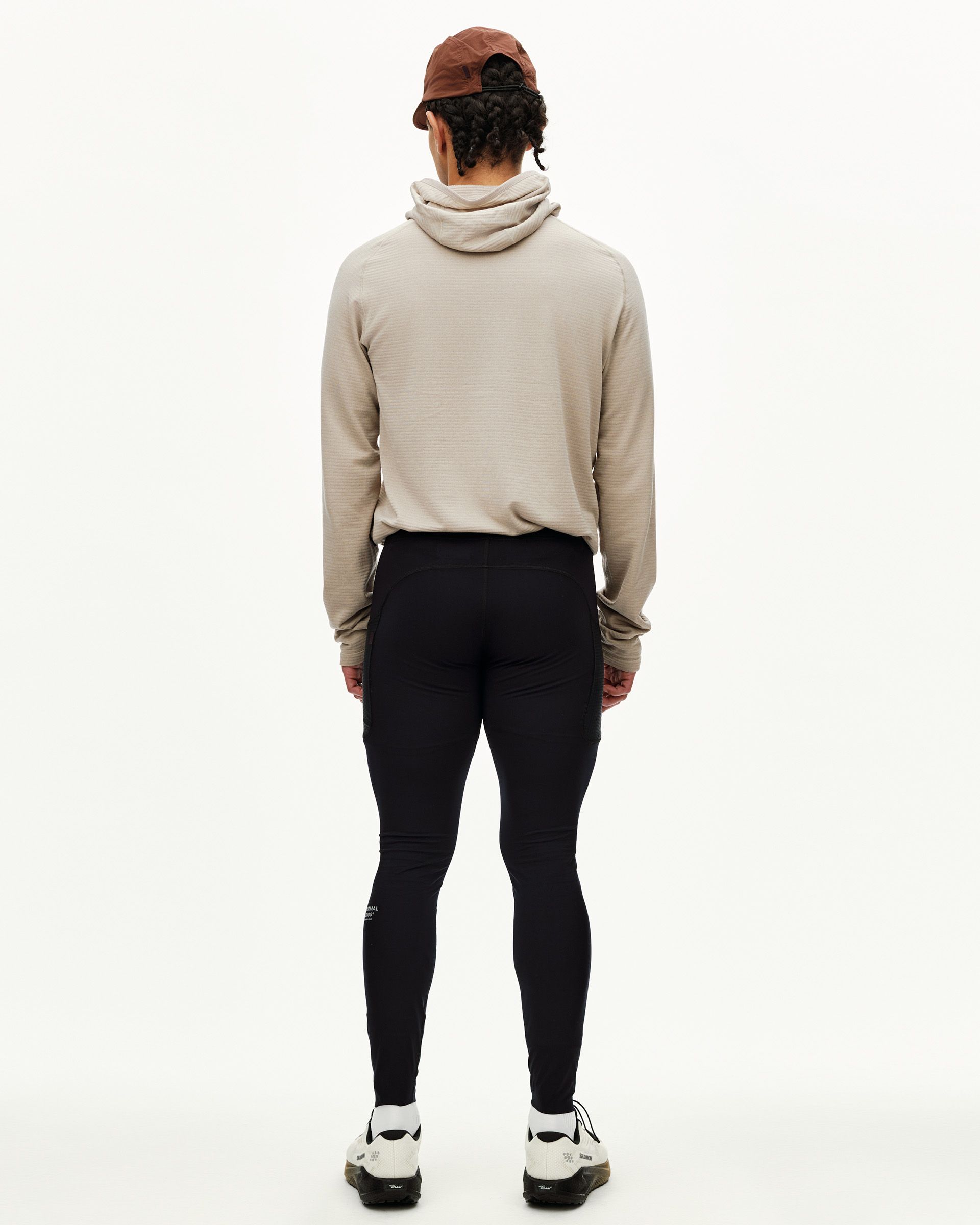 Black Balance long cycling tights on model, rear view with side pockets