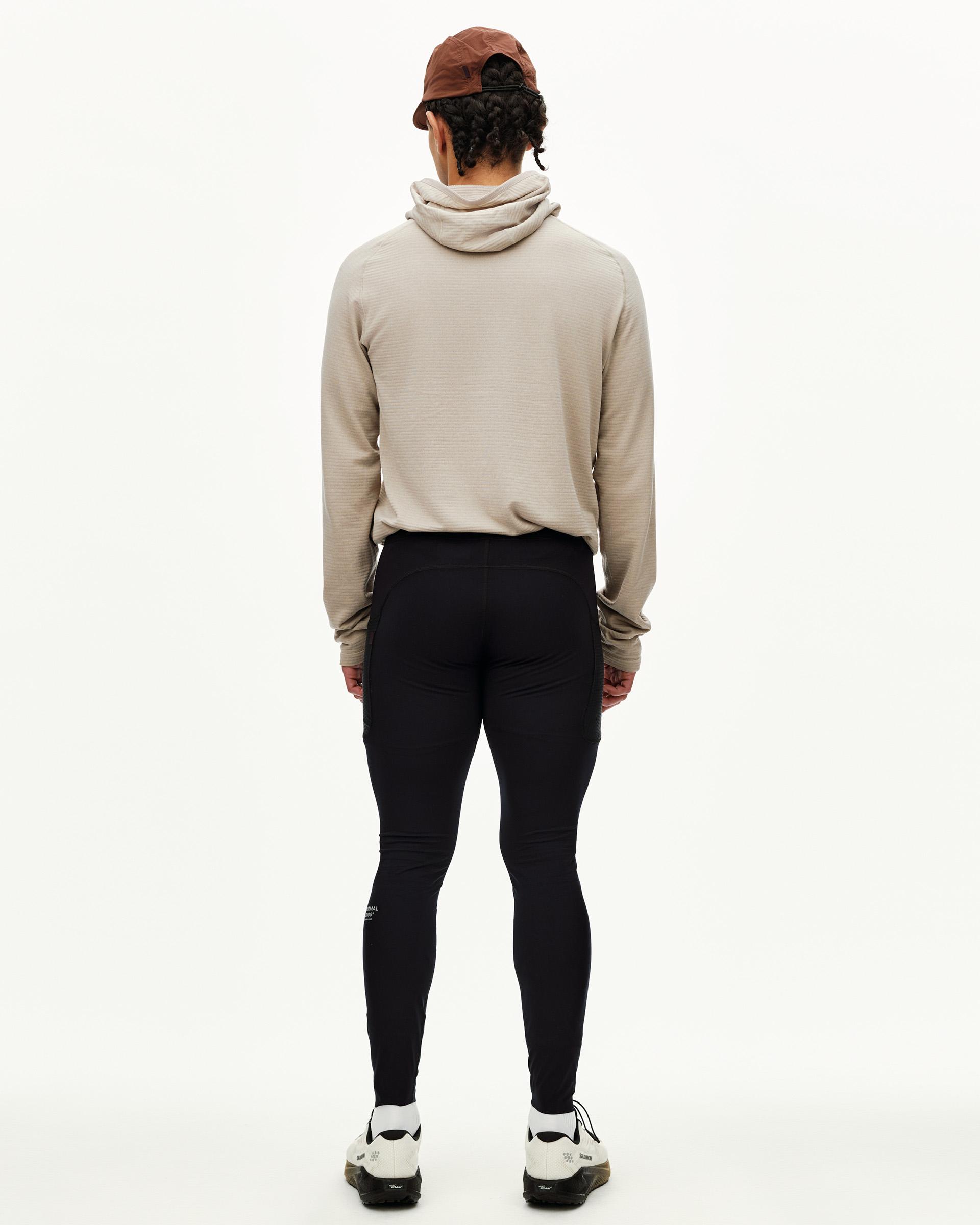 Black Balance long cycling tights on model, rear view with side pockets