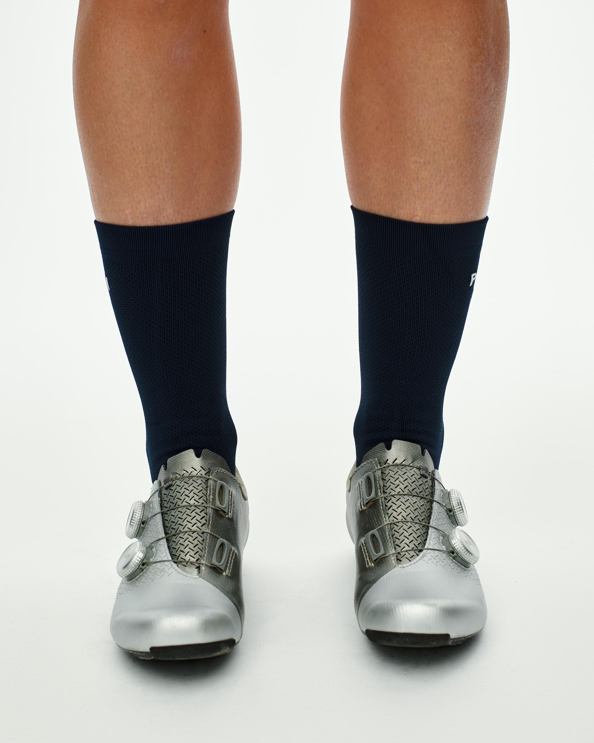Navy Essential Race cycling socks on model, front view with white logo on ankle