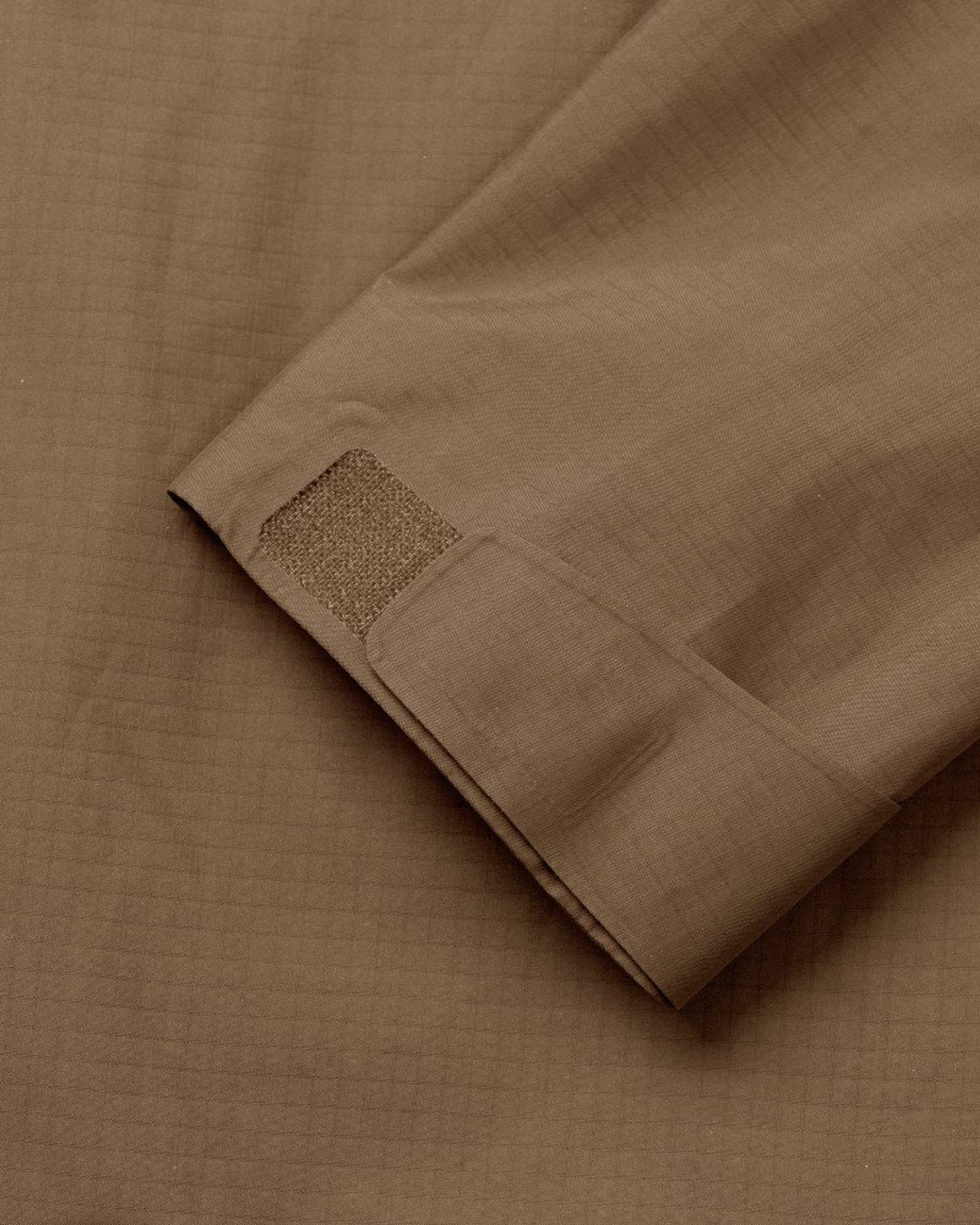 Army Brown Off-Race Shell jacket detail view showing textured square patch on sleeve cuff