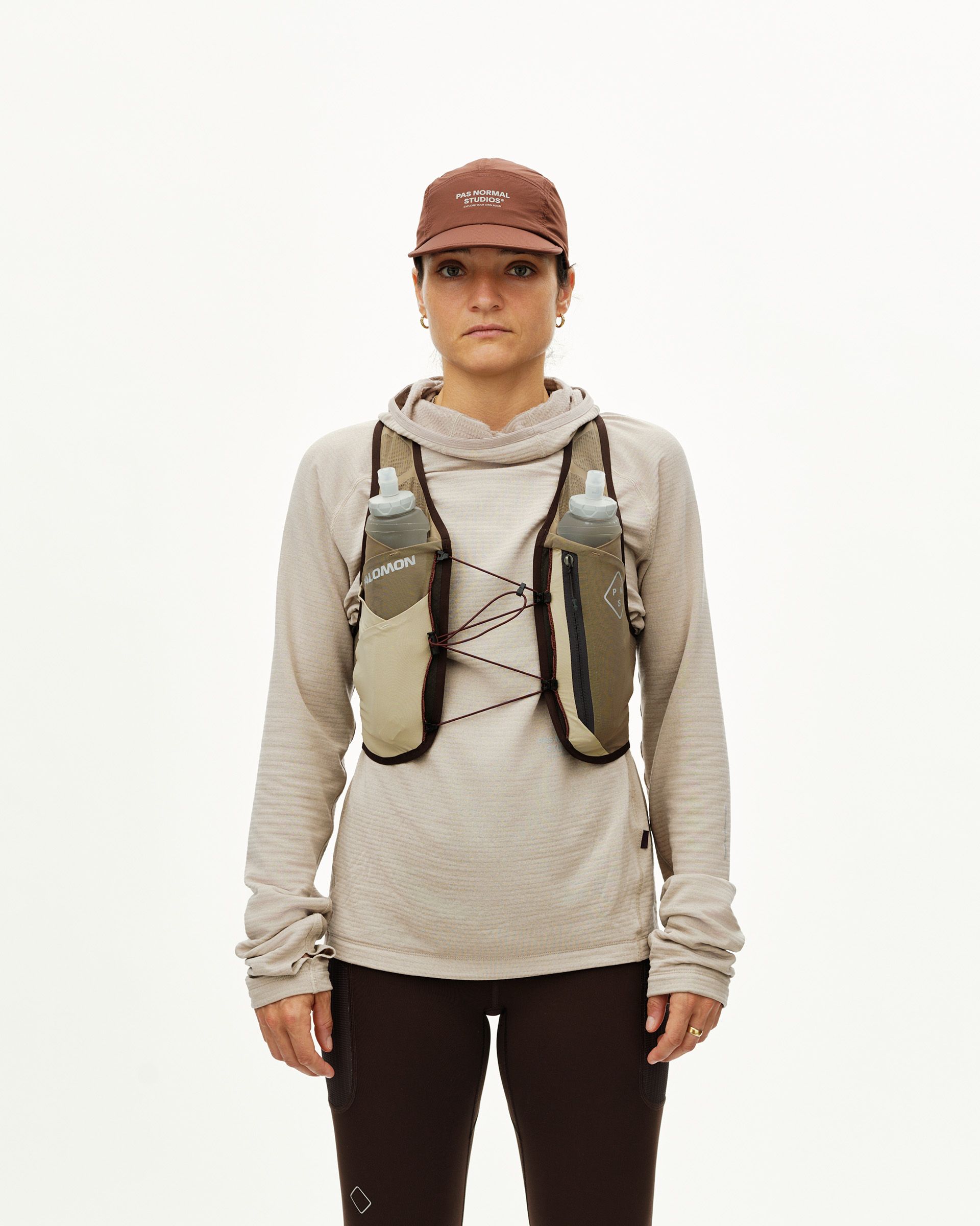 Light Brown Salomon Gravel Concept Skin 2 running vest on model, front view with two soft flasks and chest zip pocket