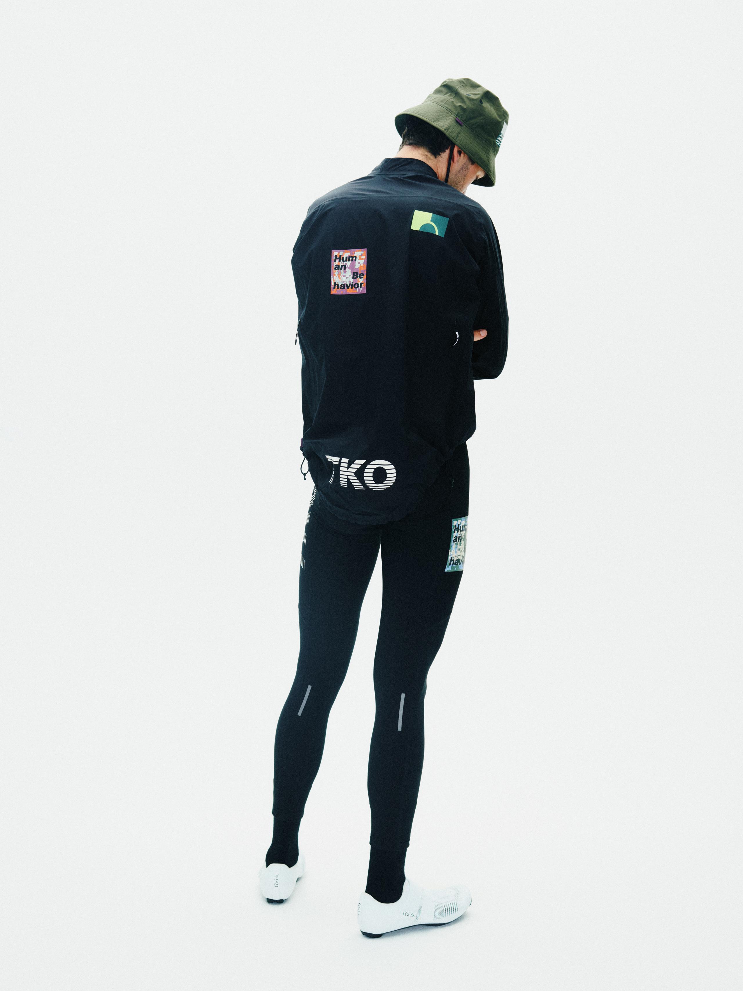 Olive T.K.O. Off-Race Shield bucket hat on model, rear view worn with black jacket and tights