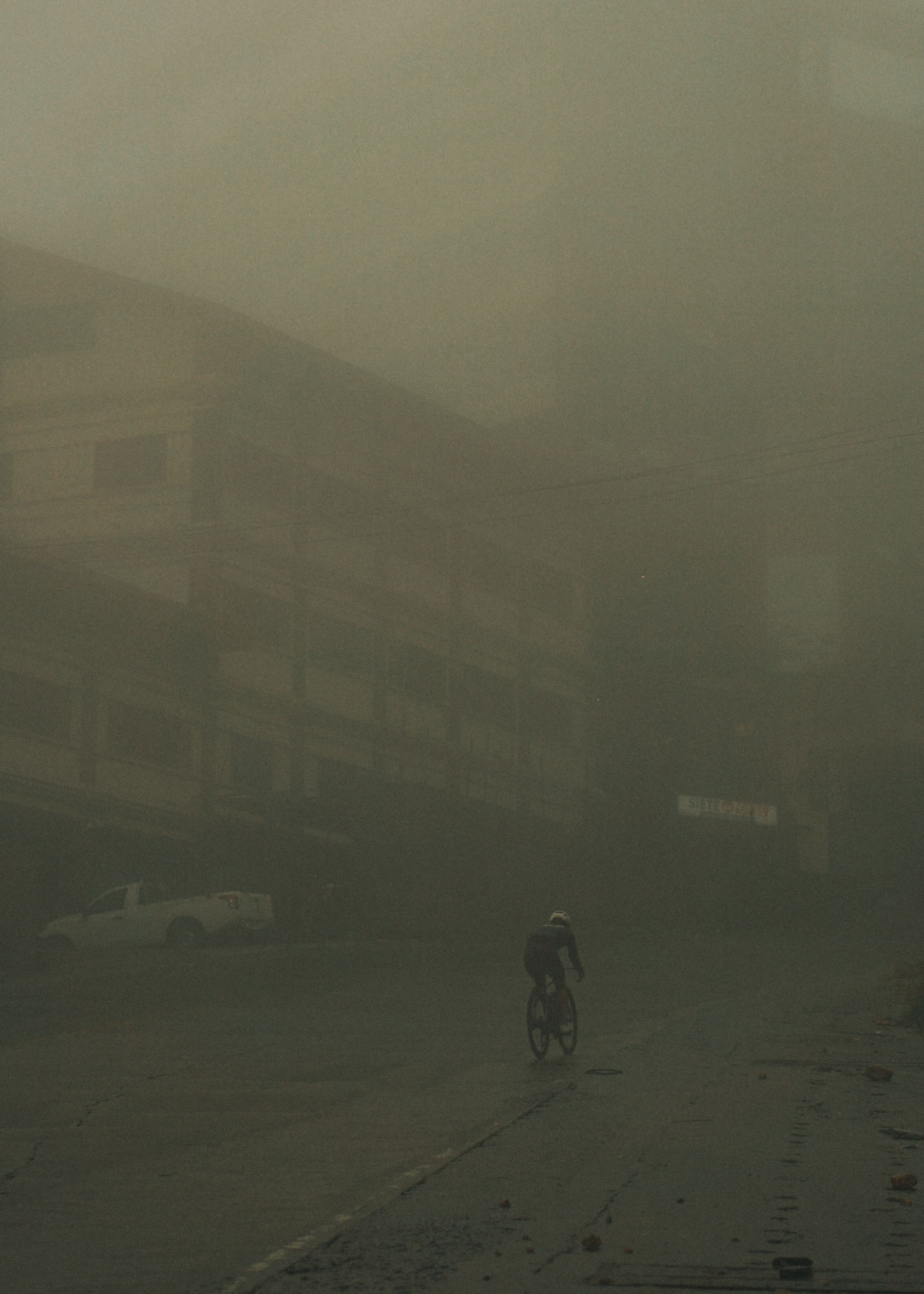 Cyclist riding through misty mountain landscape in low visibility conditions