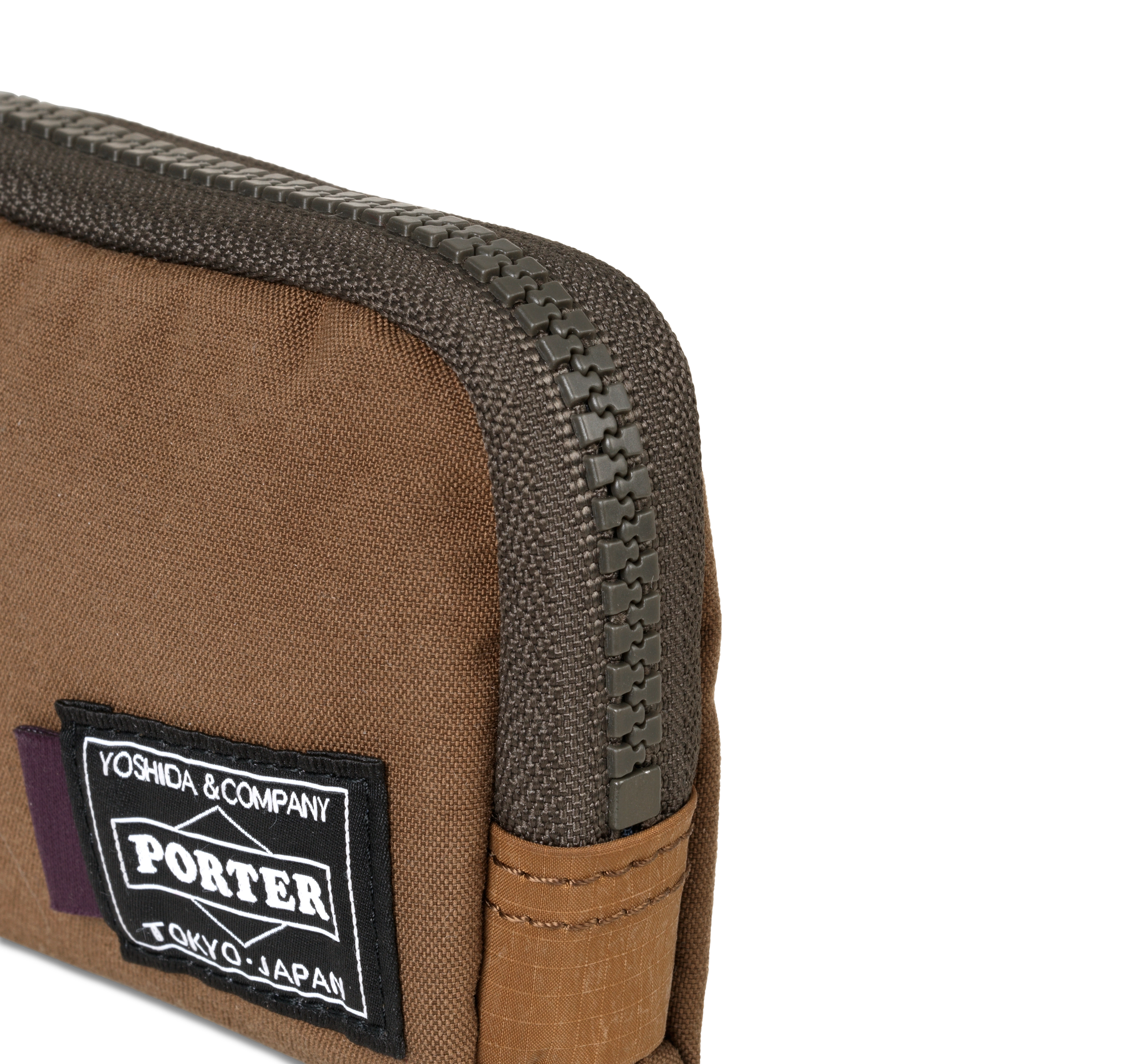 Light Brown Porter-Yoshida coin case, detail view showing dark zip and woven logo patch