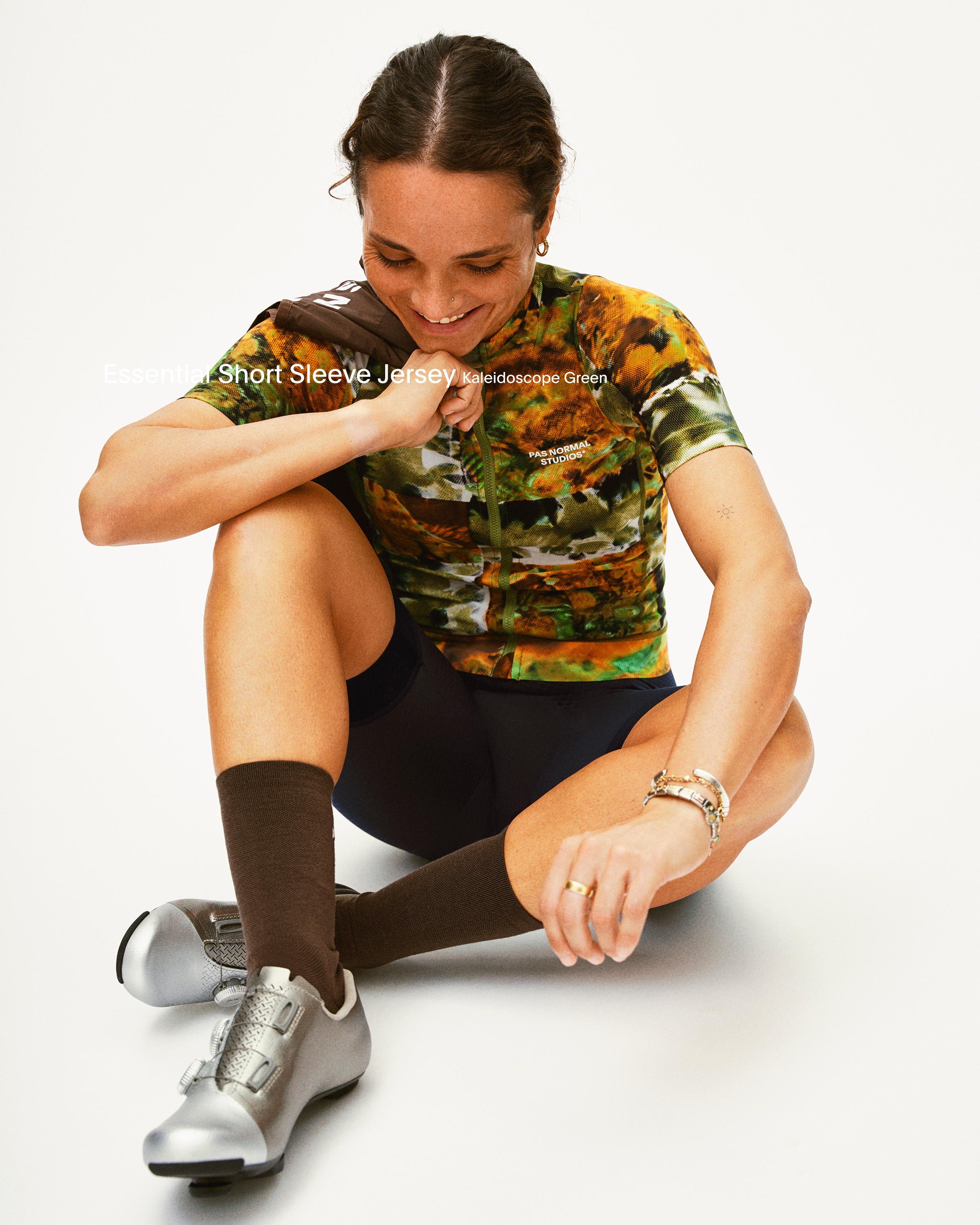 Model wearing Women's Short Sleeve Jersey in kaleidoscope green pattern with black shorts