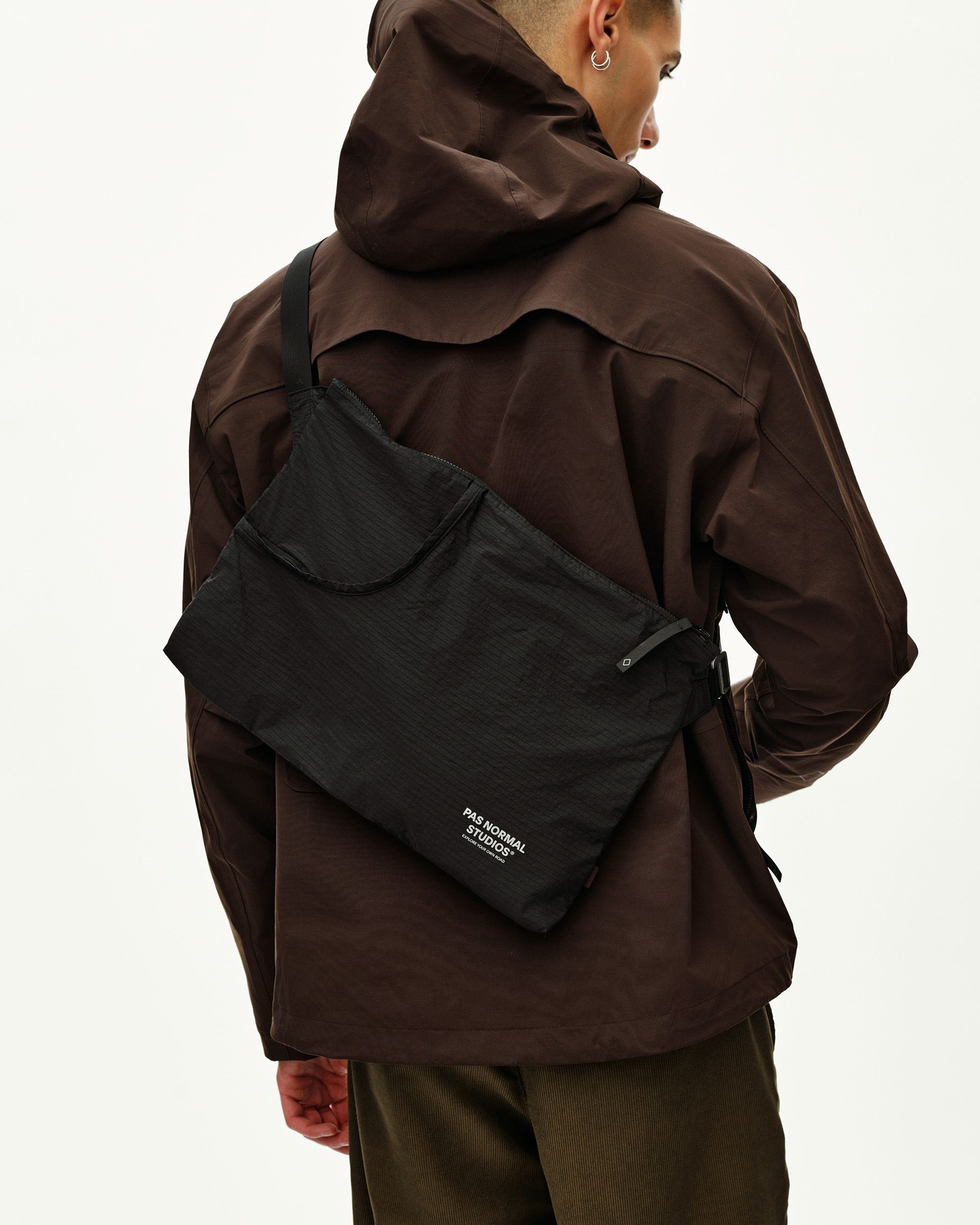 Black Off-Race Tech Musette 2.0 bag on model, rear view worn as crossbody with front pocket detail
