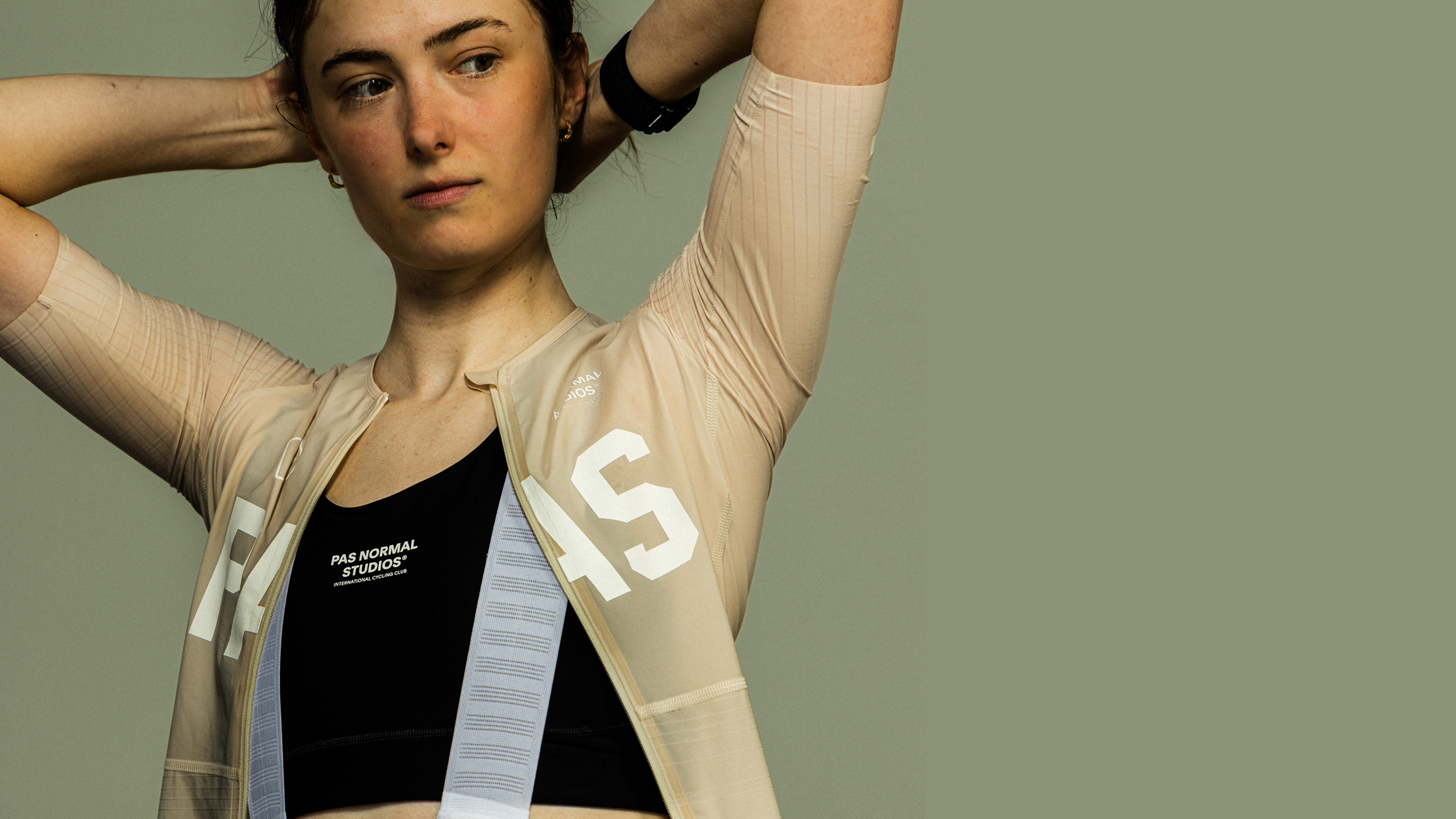 Model wearing Women's Mechanism Long Sleeve Jersey in beige with white lettering and ribbed sleeves