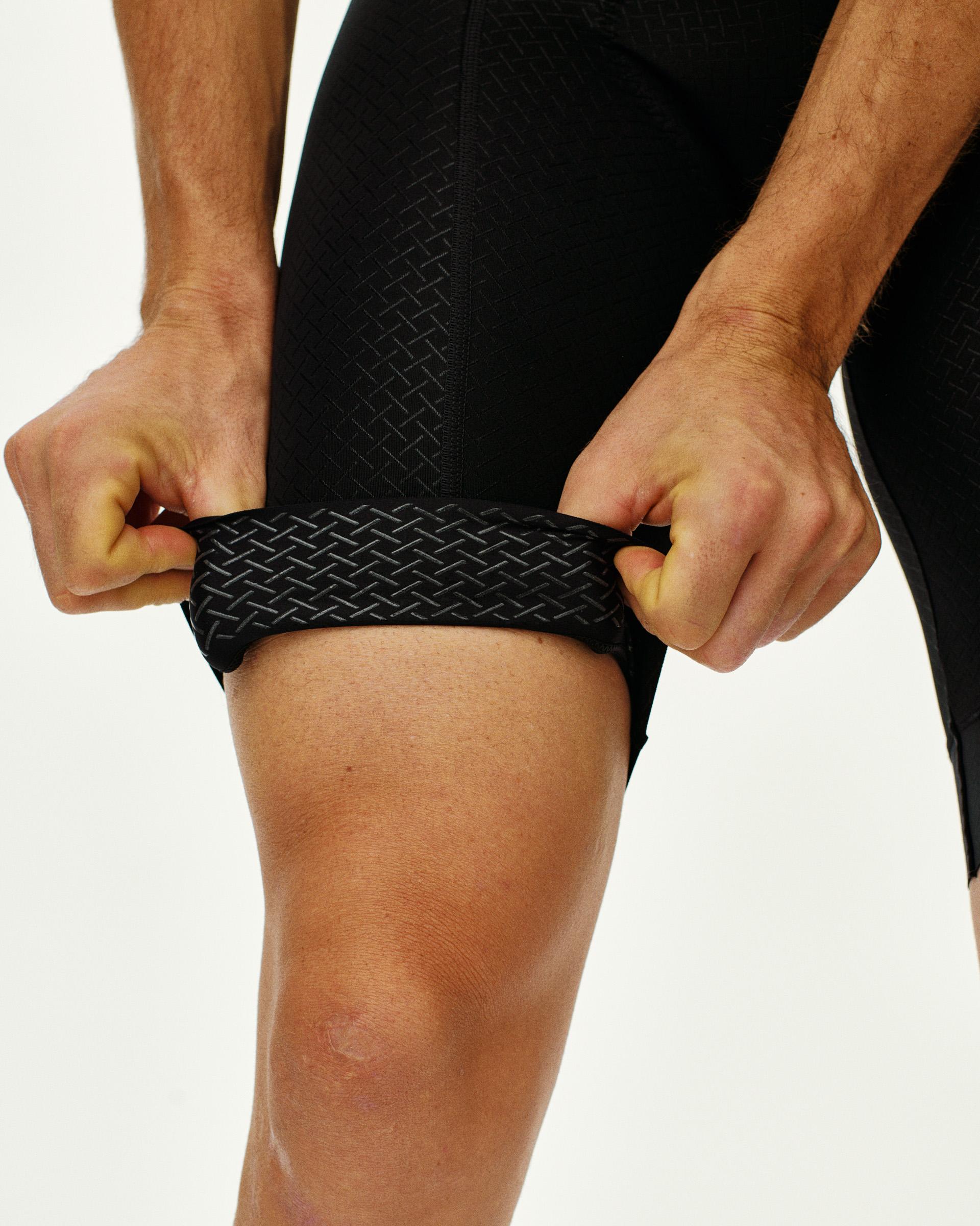 Black Mechanism cycling bibs on model showing textured leg gripper detail