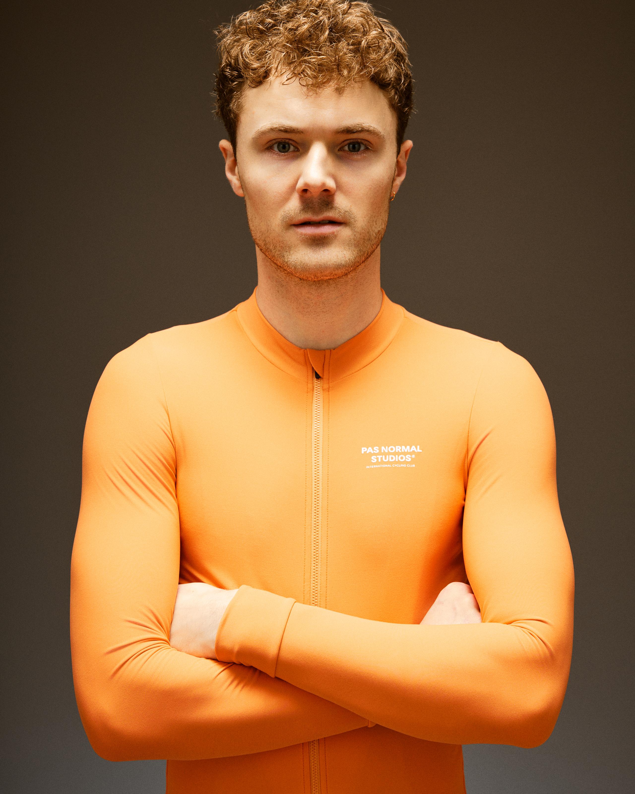 Orange Mechanism long sleeve cycling jersey on model with full zip and white chest logo