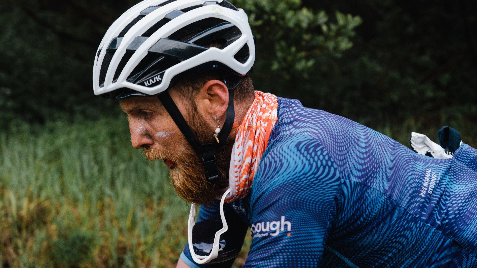 Model wearing blue patterned jersey in cycling position outdoors