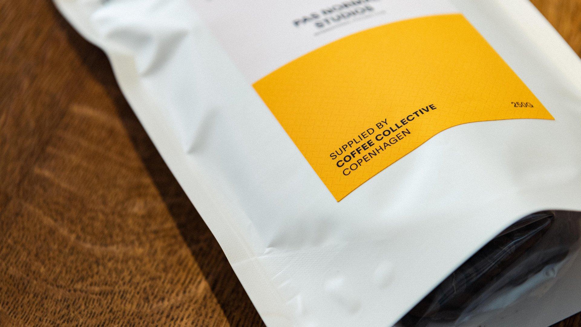 Coffee Collective Copenhagen packaging with orange label on wooden surface