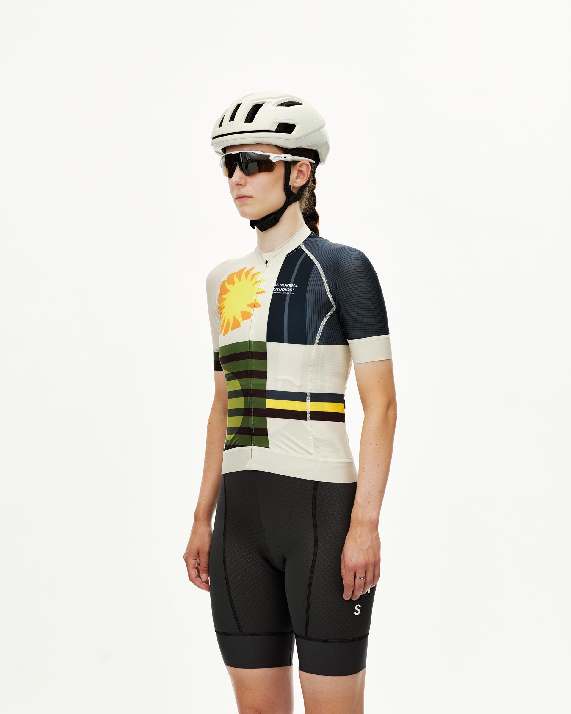 International Sand Mechanism women's cycling jersey on model, three-quarter front view with sun and stripe graphic print
