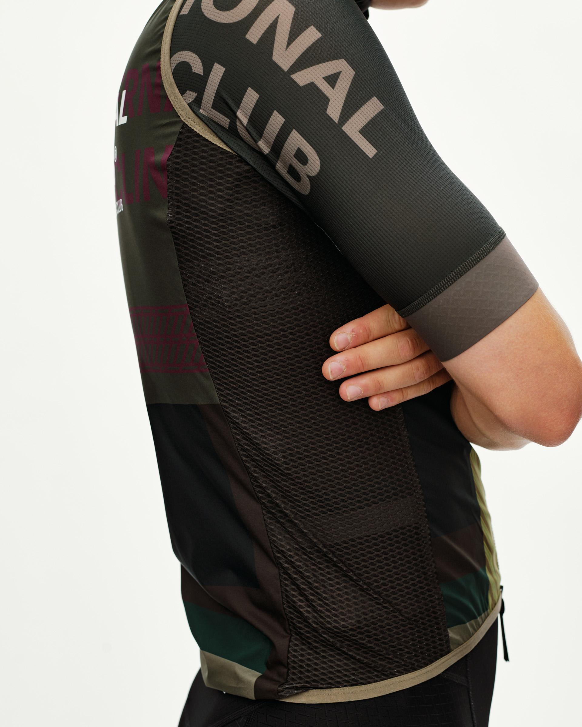 Dusty Earth khaki Mechanism Stow Away gilet, side detail on model with mesh side panel and graphic sleeve print
