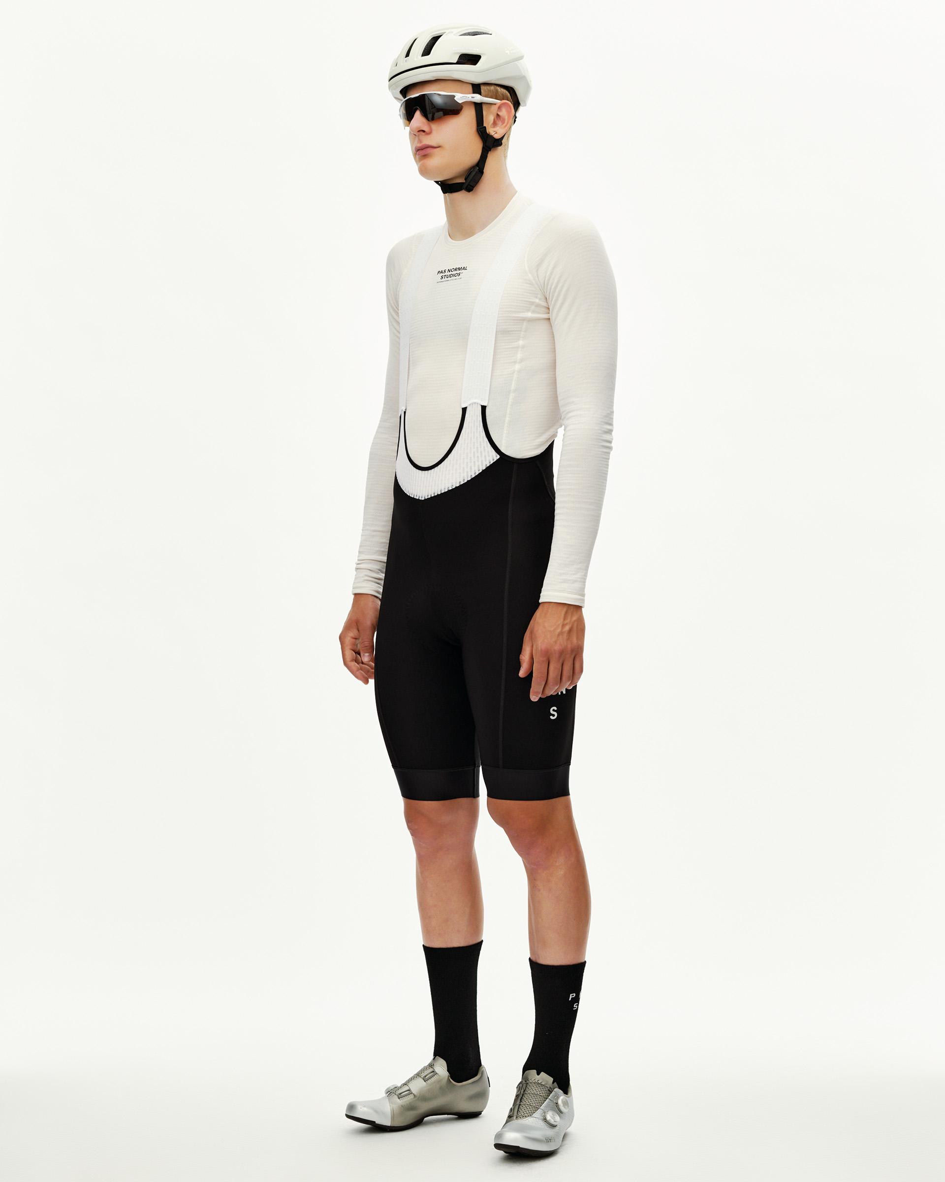 Black Mechanism Thermal cycling bibs on model, three-quarter front view with white ribbed bib straps