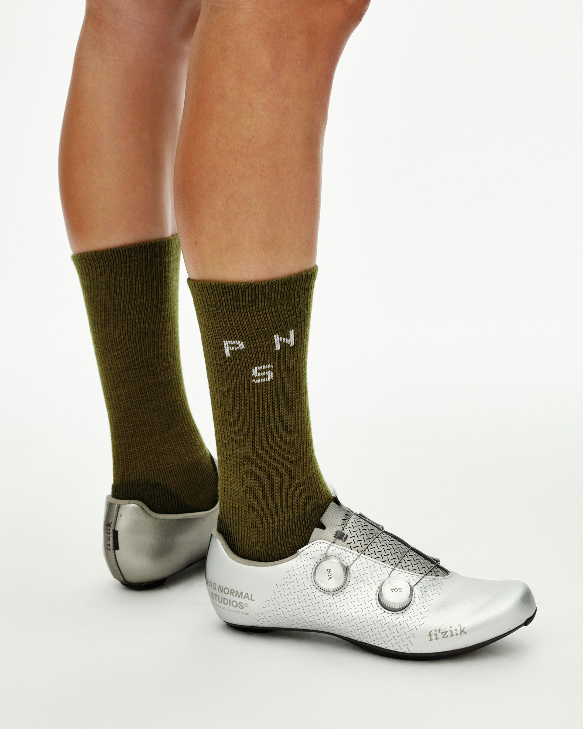 Khaki Green Deep Winter Wool cycling socks on model, side view with white PNS logo knit into cuff