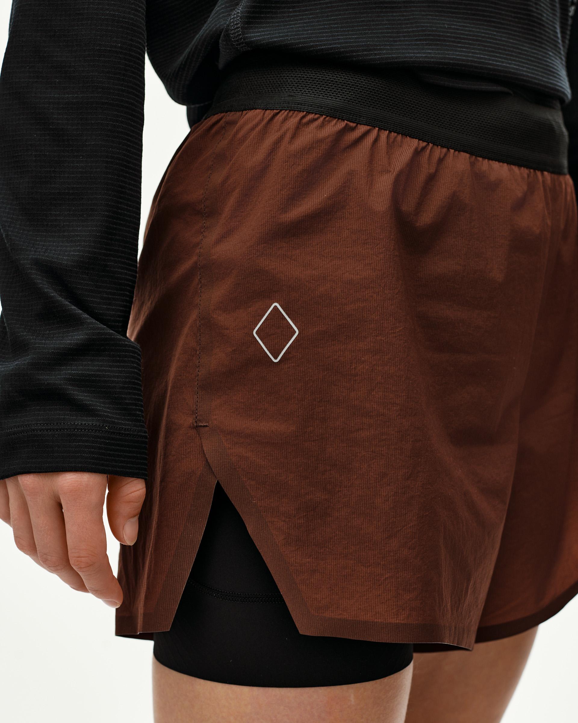 Maroon Brown Balance 2-in-1 shorts, side detail on model with split hem and diamond logo print