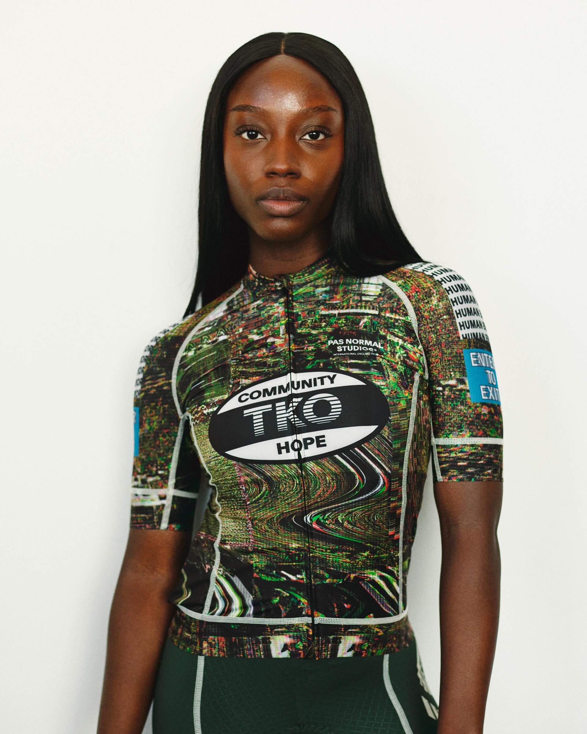 Human Error Green T.K.O. Mechanism women's cycling jersey on model, front view with all-over glitch print and blue sleeve