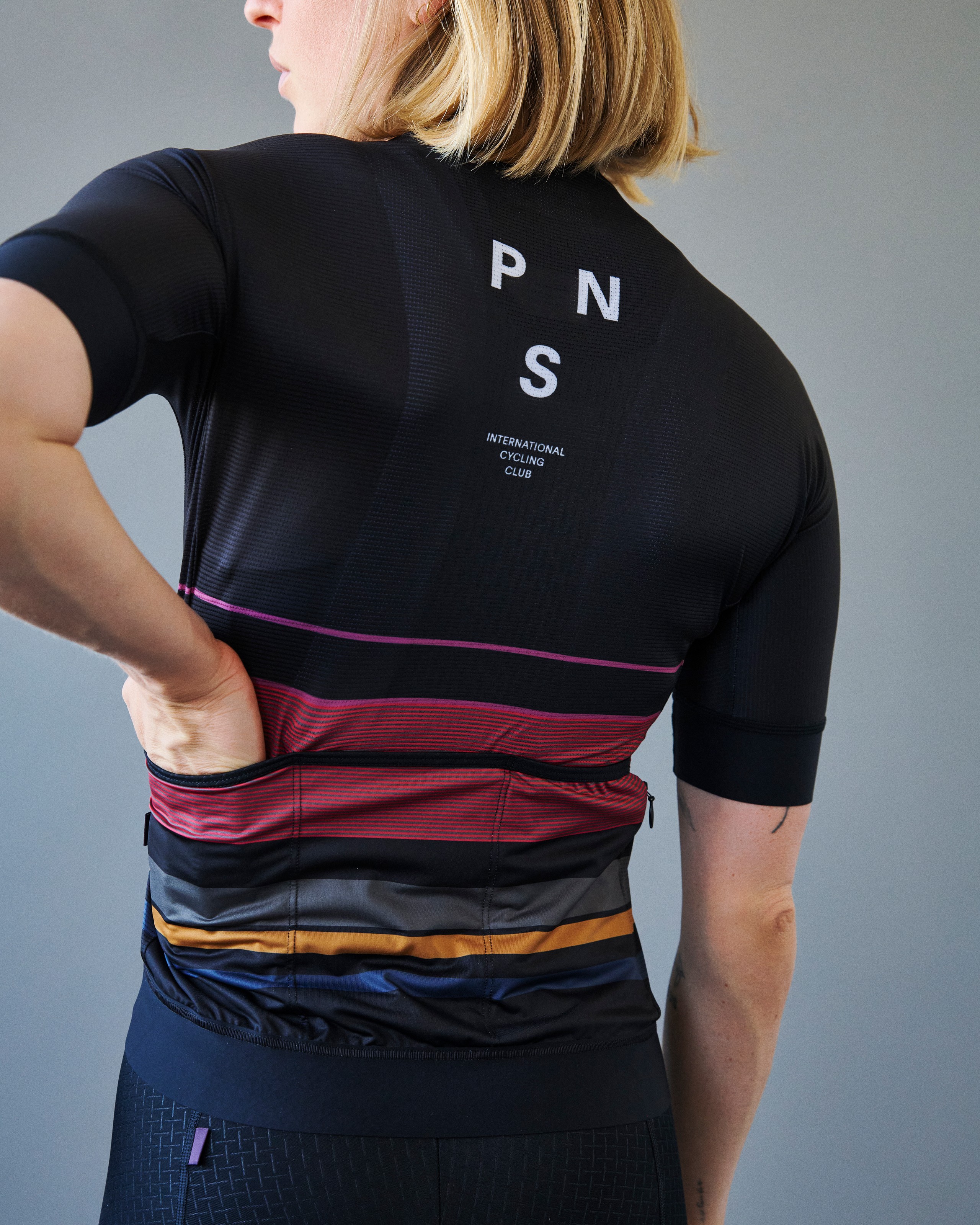 Back view of cycling jersey showing three elastic rear pockets with concealed zippered side pocket for secure storage