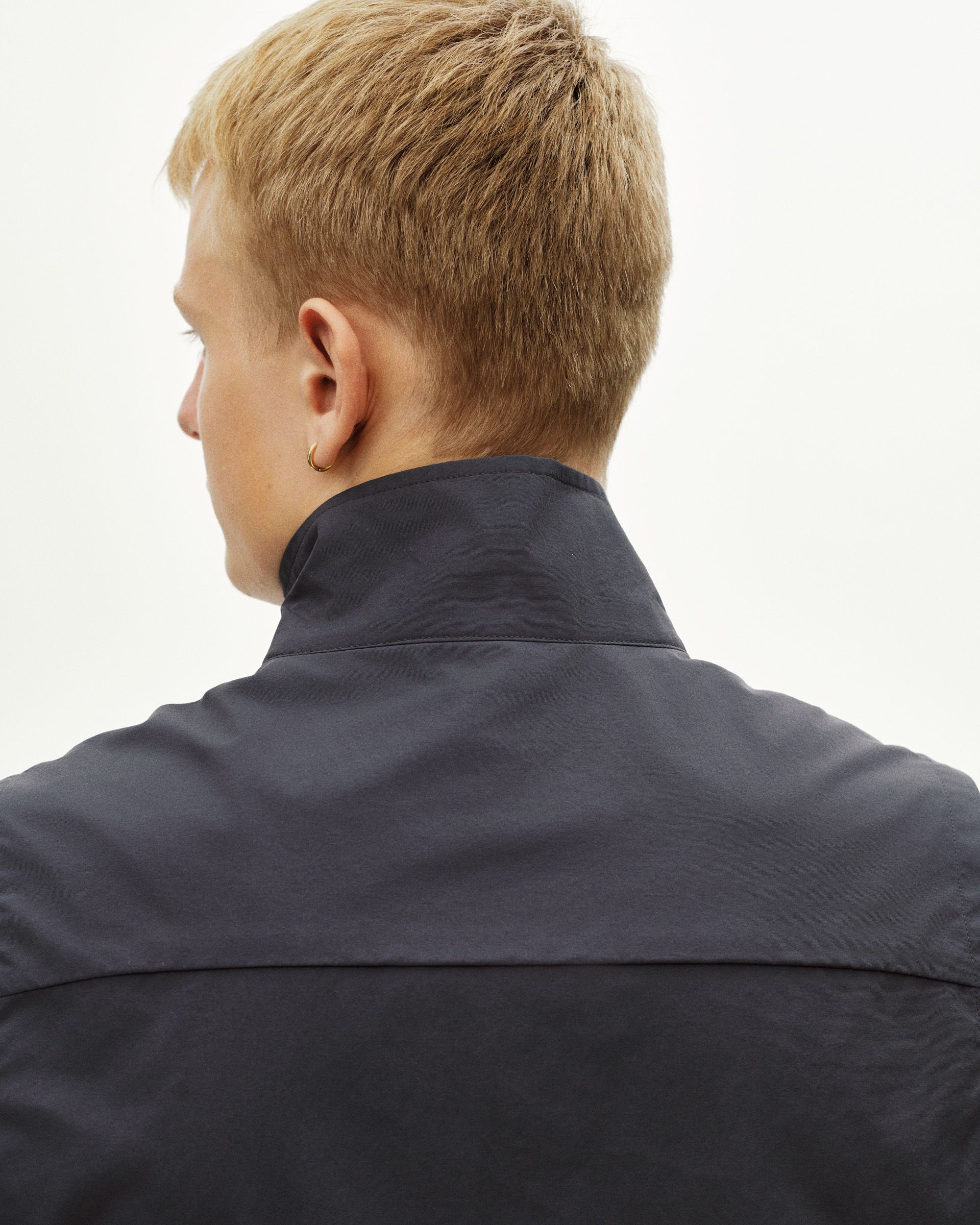 Grey Off-Race Utility vest, rear view on model showing high collar and seamed construction