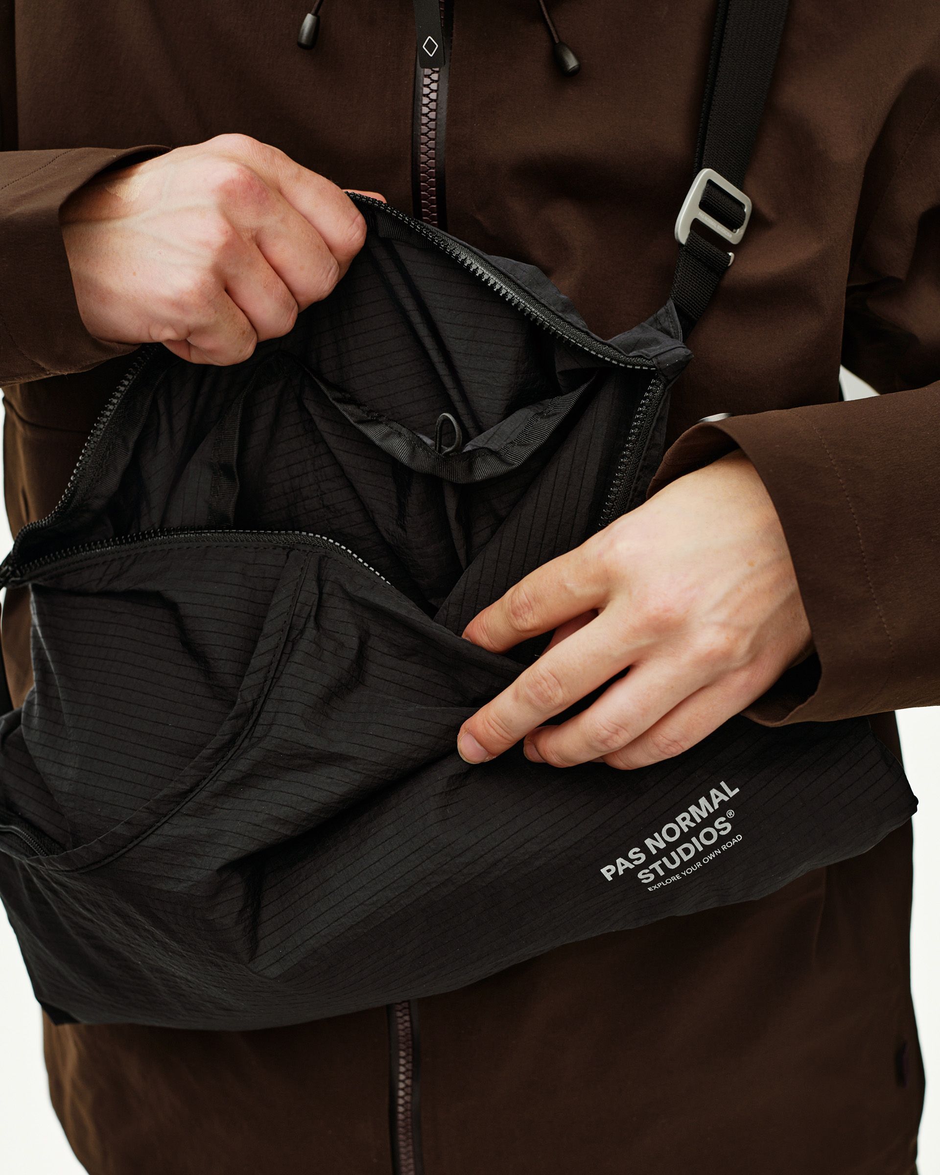 Black Off-Race Tech Musette 2.0 bag, detail view opened on model showing ripstop interior compartments