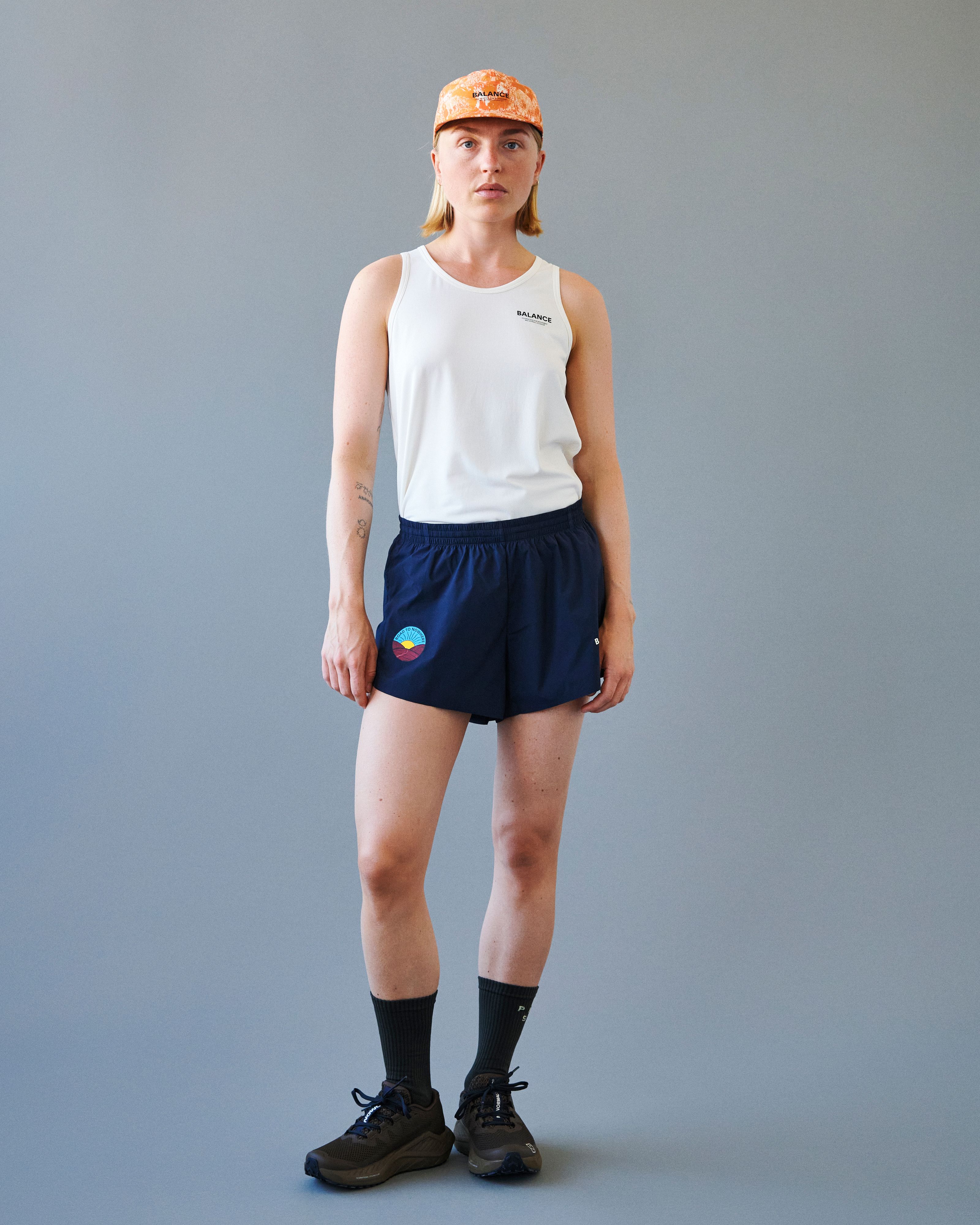 Navy Balance shorts on model with elastic waistband and colorful circular logo