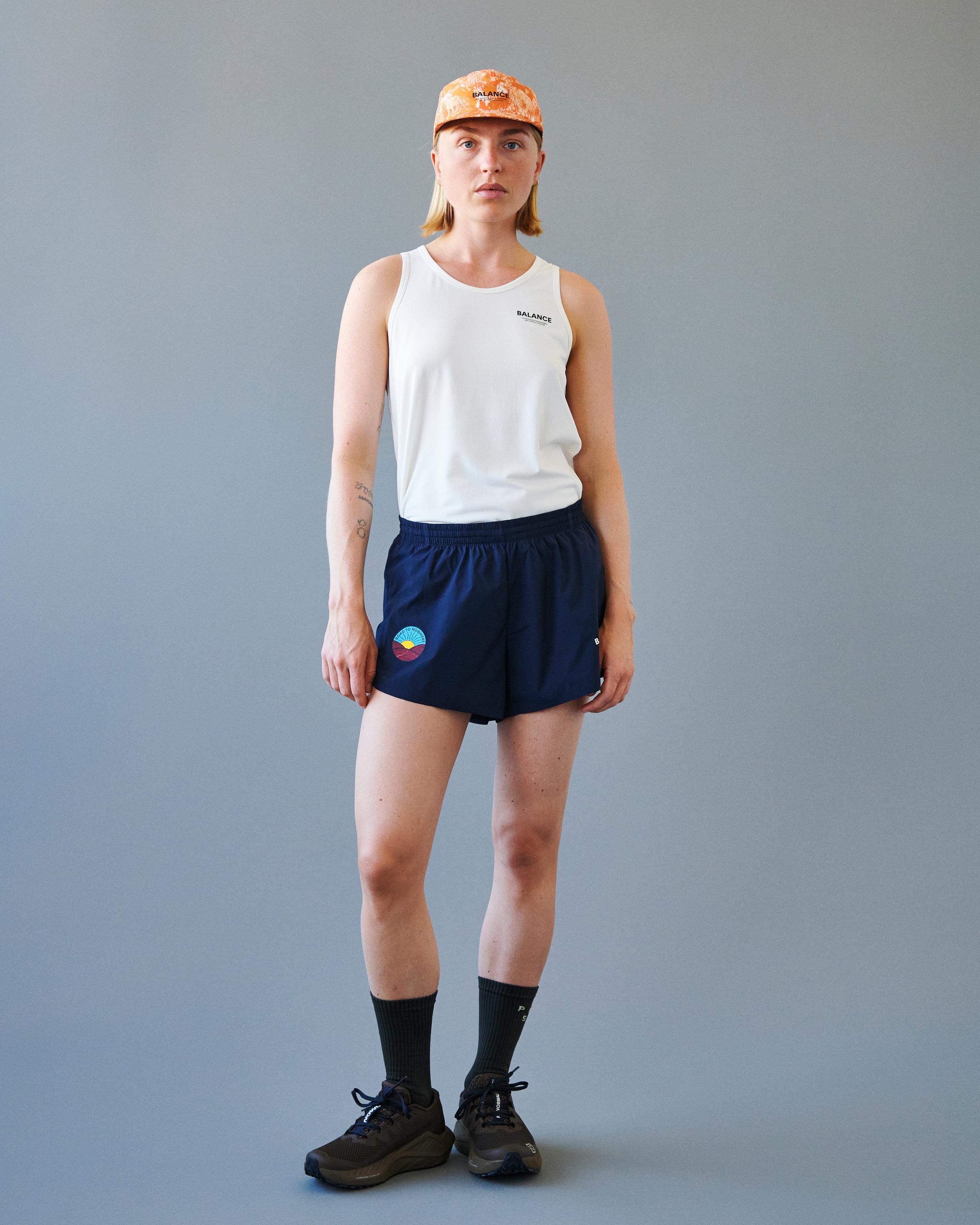 Navy Balance shorts on model with elastic waistband and colorful circular logo