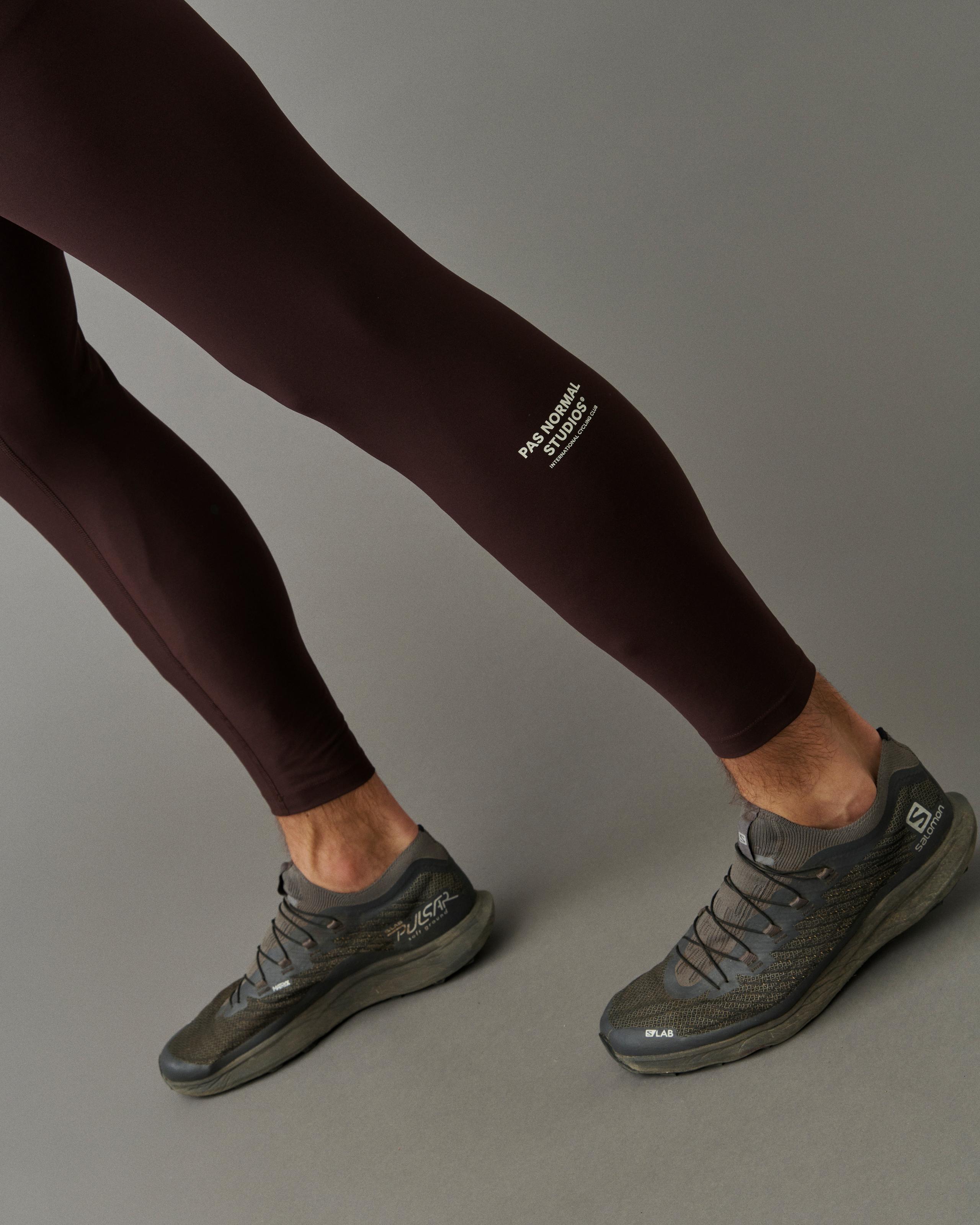 Dark Red Balance long tights on model with green Salomon running shoes