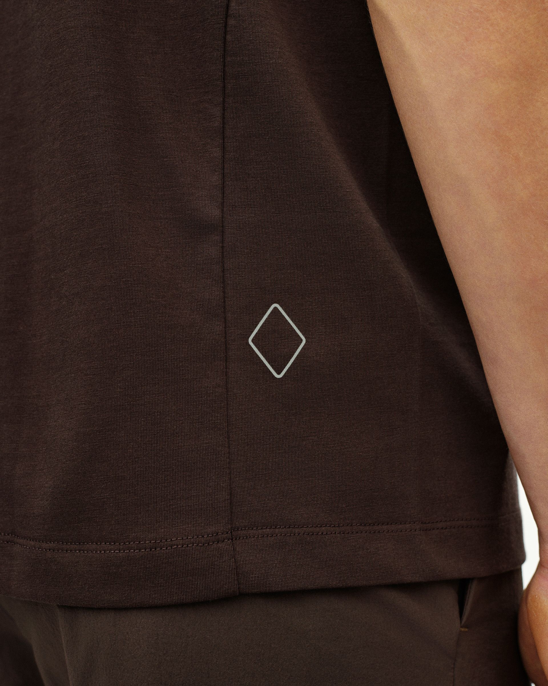 Dark Purple Off-Race Cotton Tech t-shirt, detail view showing white diamond logo on hem