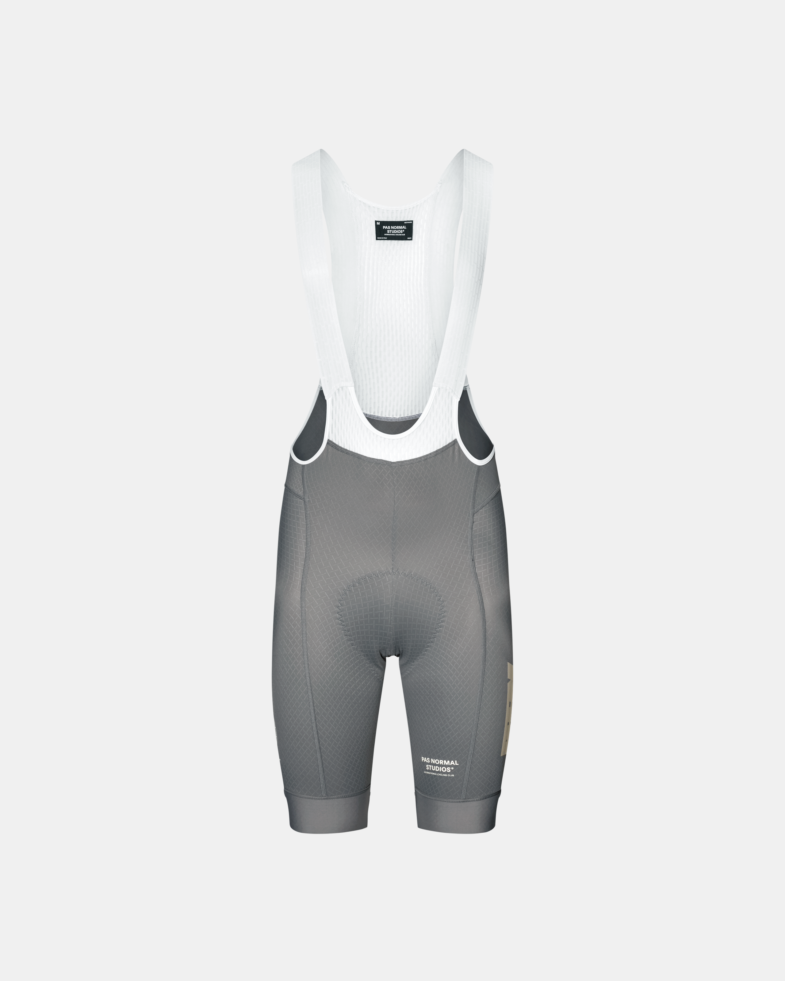 Medium Grey Mechanism cycling bibs, front flat lay with white ribbed bib straps and gold side logo