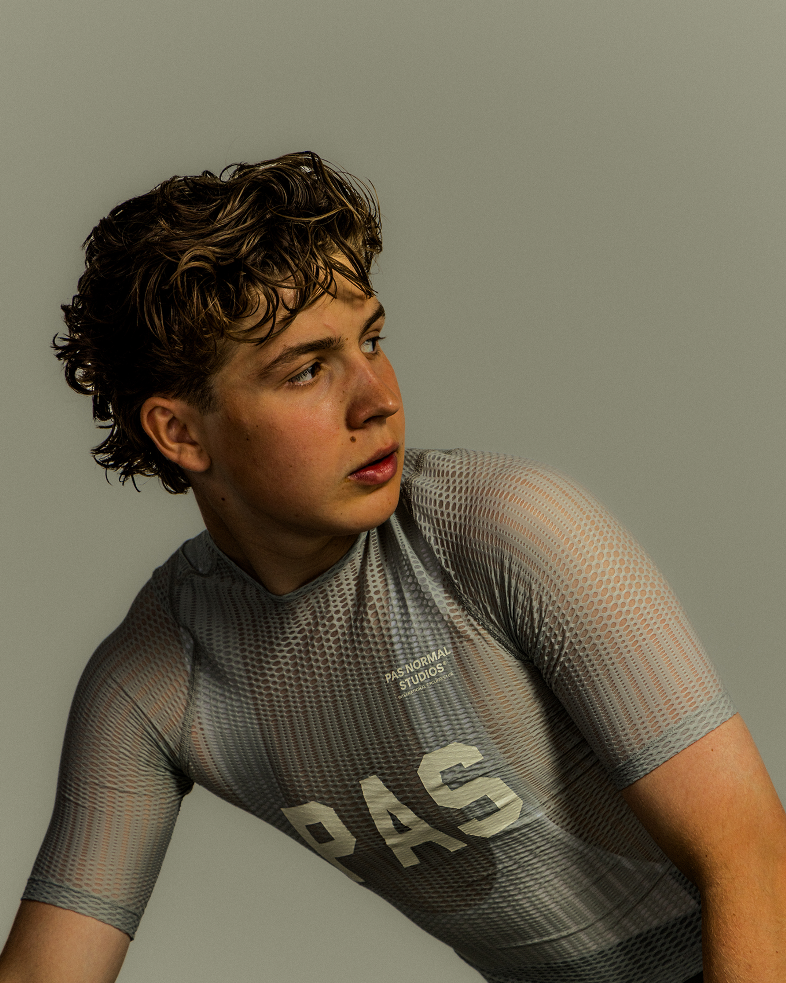 Model wearing Women's PAS Mechanism Jersey in grey with mesh texture and chest lettering in studio shot